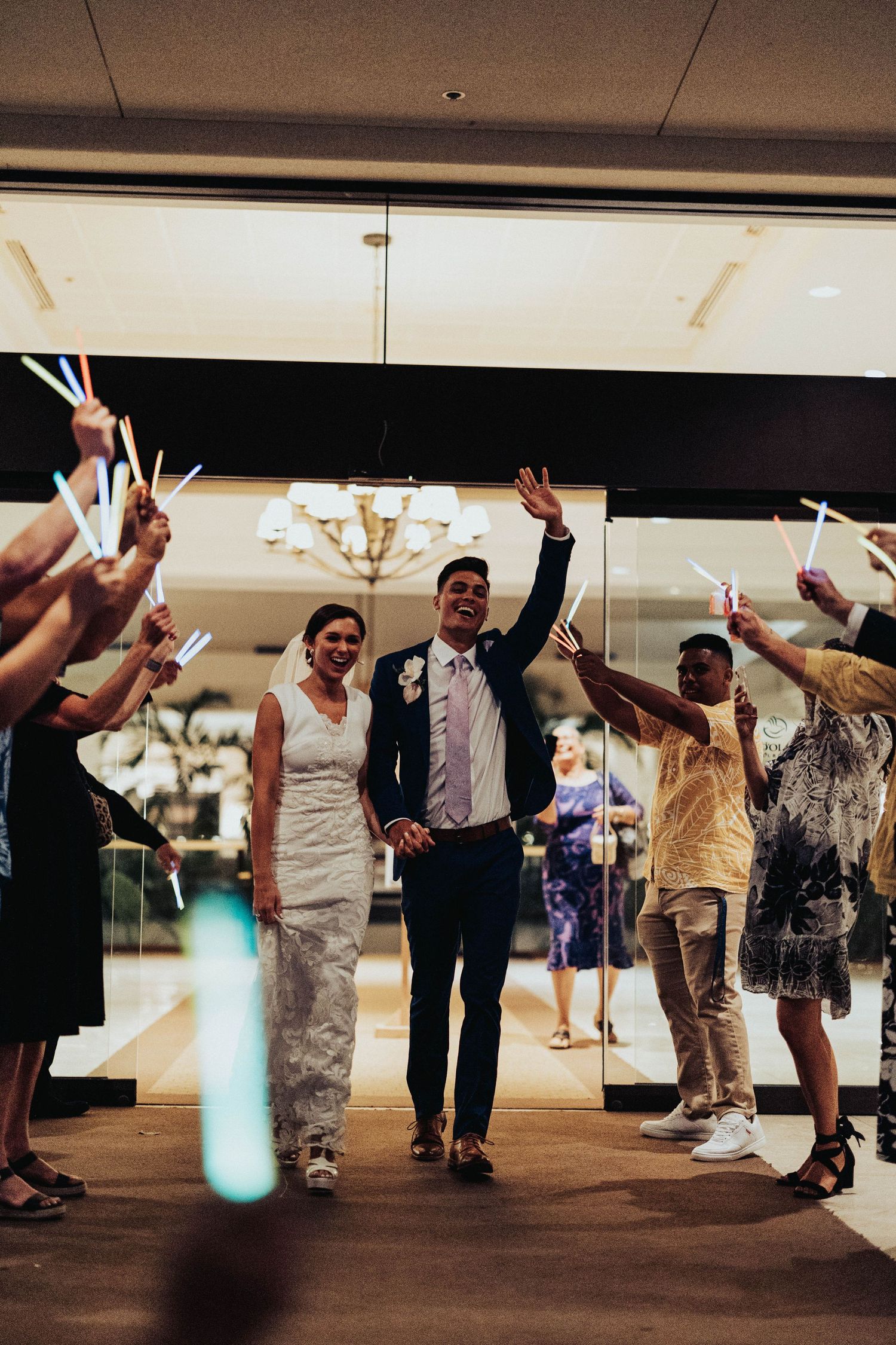 Wedding guests dance together on the ballroom floor during an evening reception celebration.