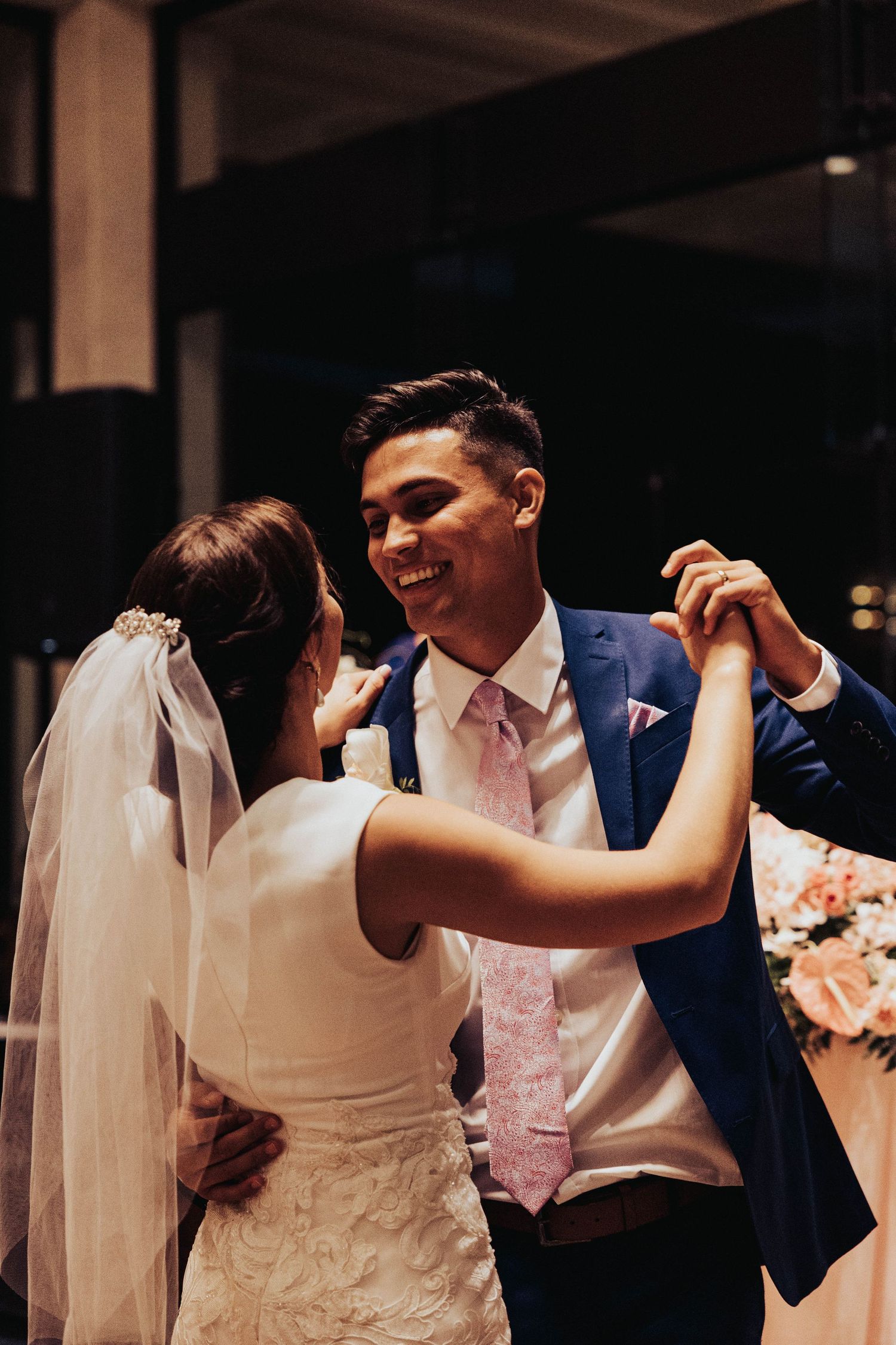 Wedding guests dancing together at an evening reception in elegant formal attire.