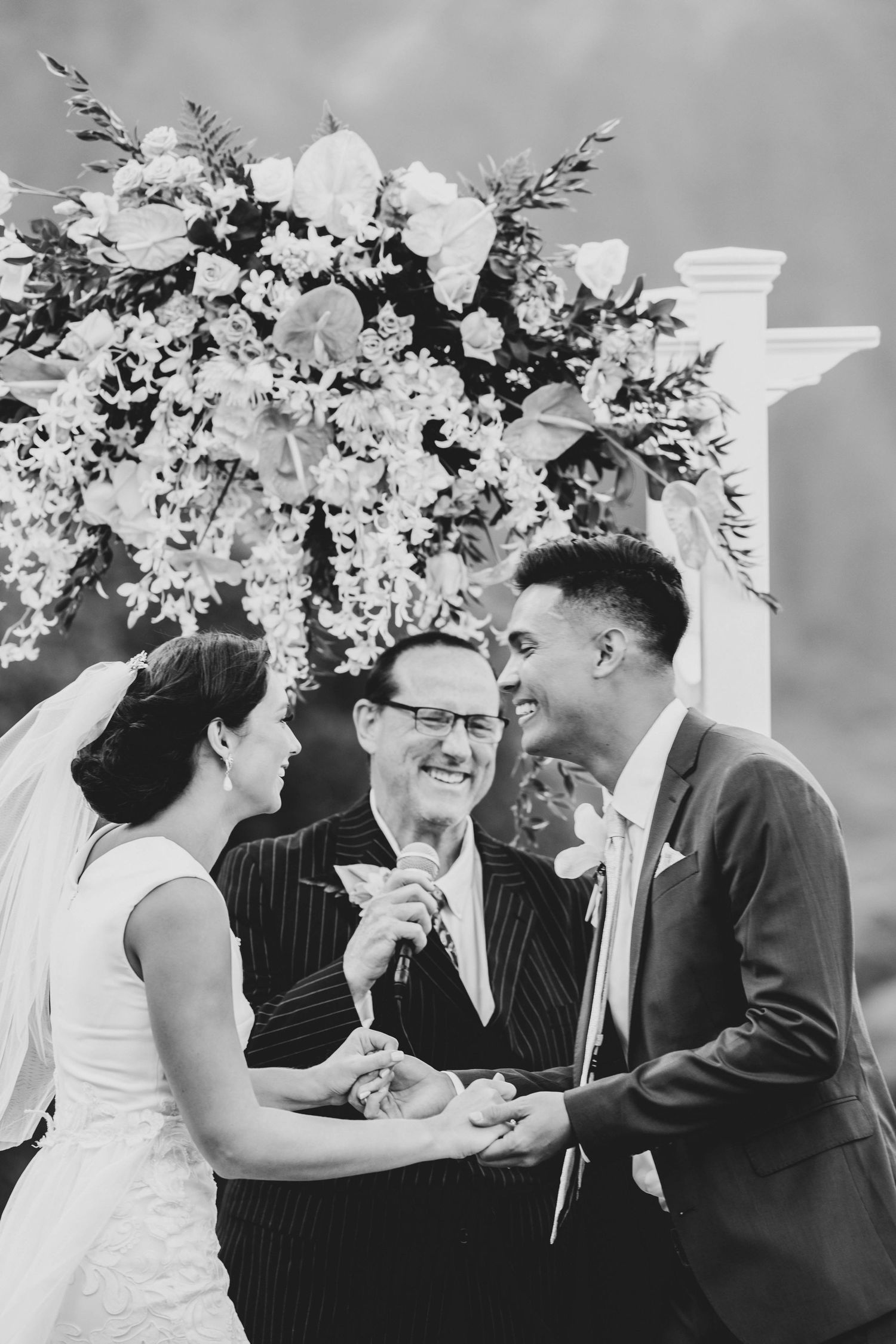 A series of black and white wedding photos showing joyful moments between couples and guests at an elegant reception.