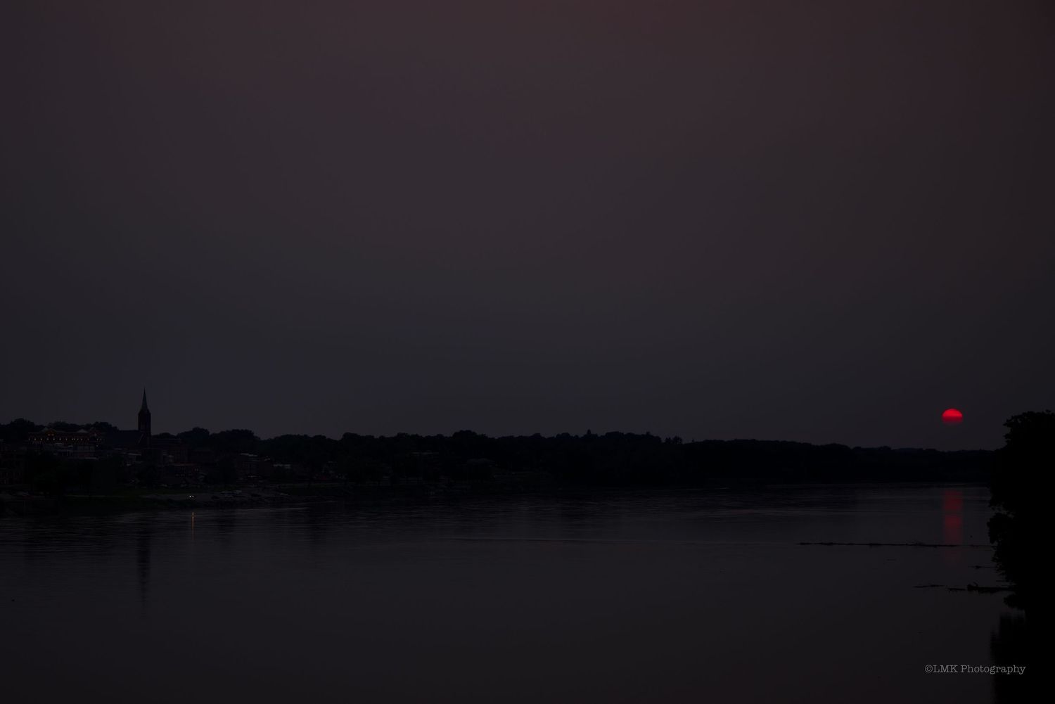 Wildfires forcing the setting sun to turn RED on a cloudy, hazy day.