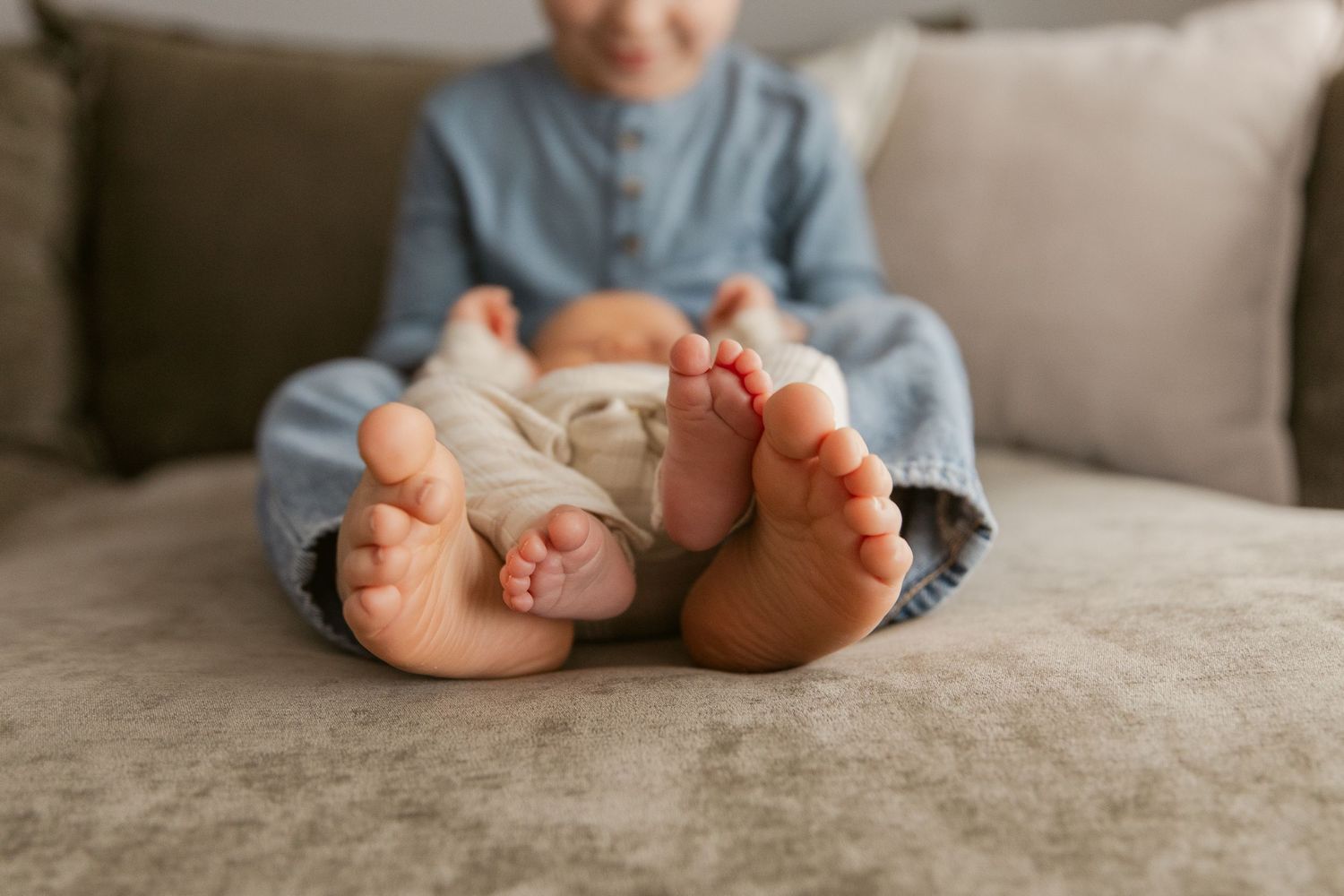 Bare feet and legs shown on a gray couch in a series of casual poses.