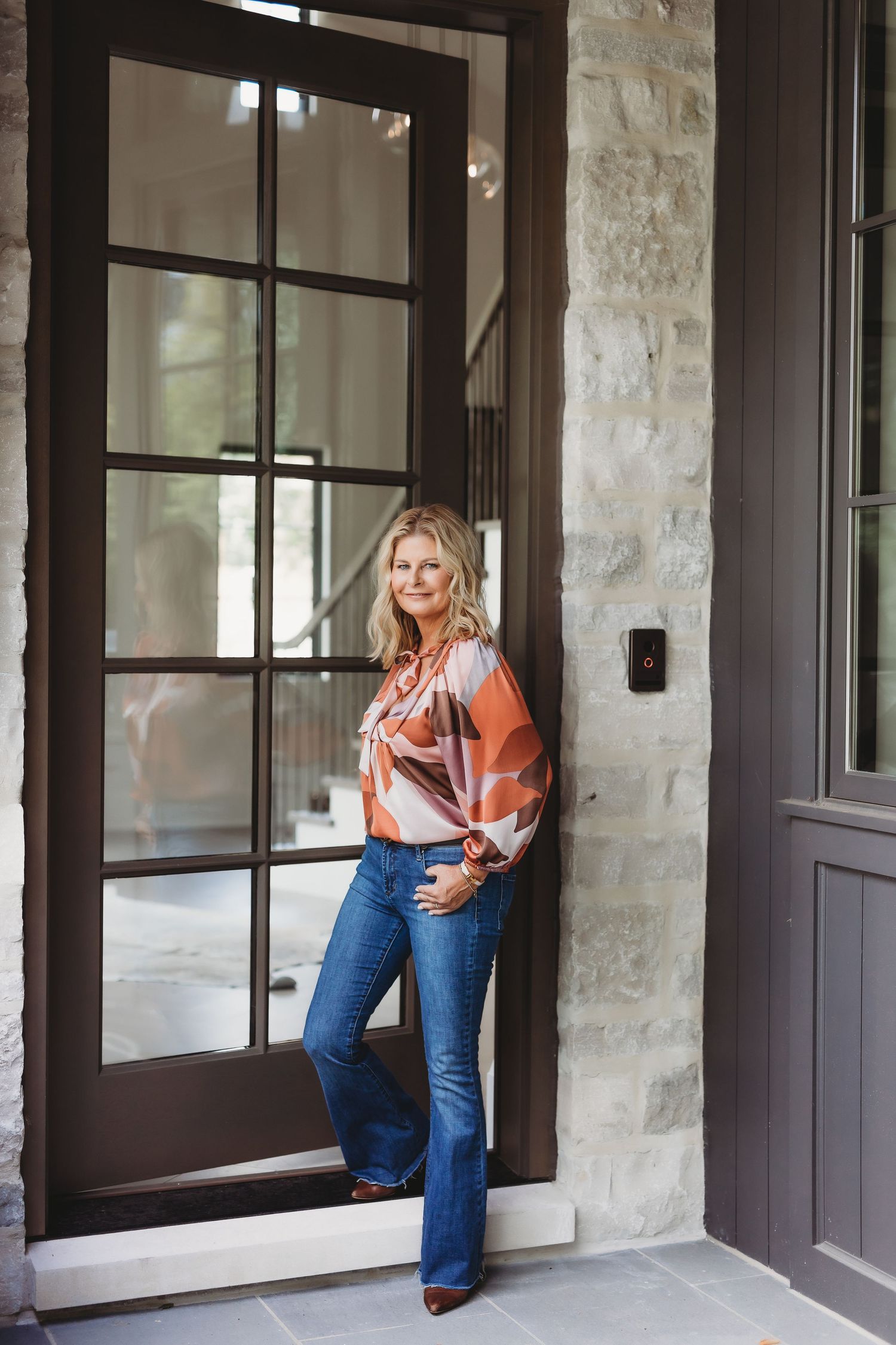 Casual outdoor portraits against stone wall exterior with dark framed windows.