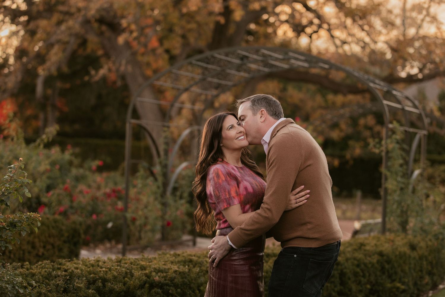 Intimate autumn photoshoot in park with warm sunset lighting and fall colors.