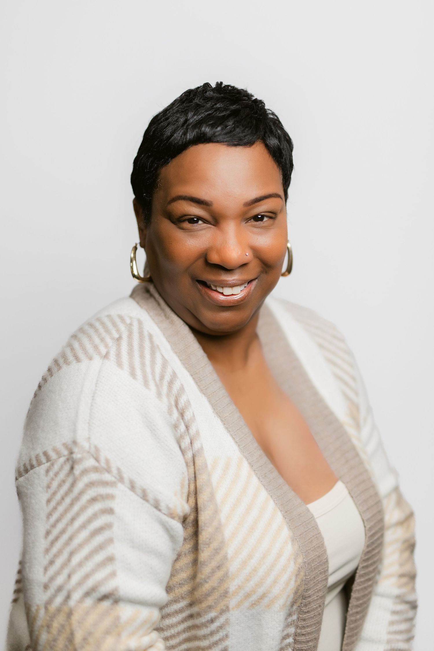 Professional portraits of a person in a textured white sweater against light backdrop.