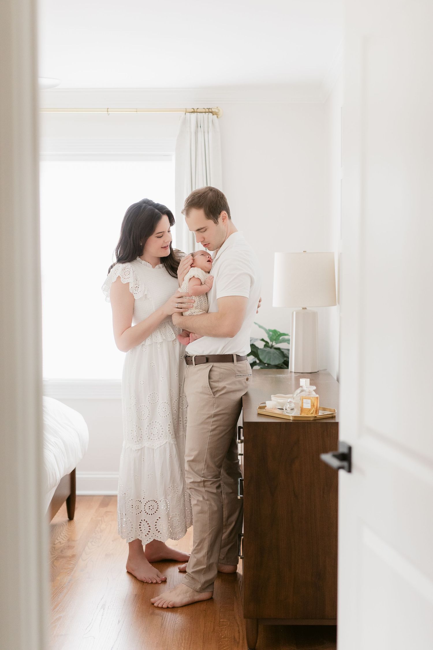 Sunlit room with wooden floors and white walls featuring modern decor.