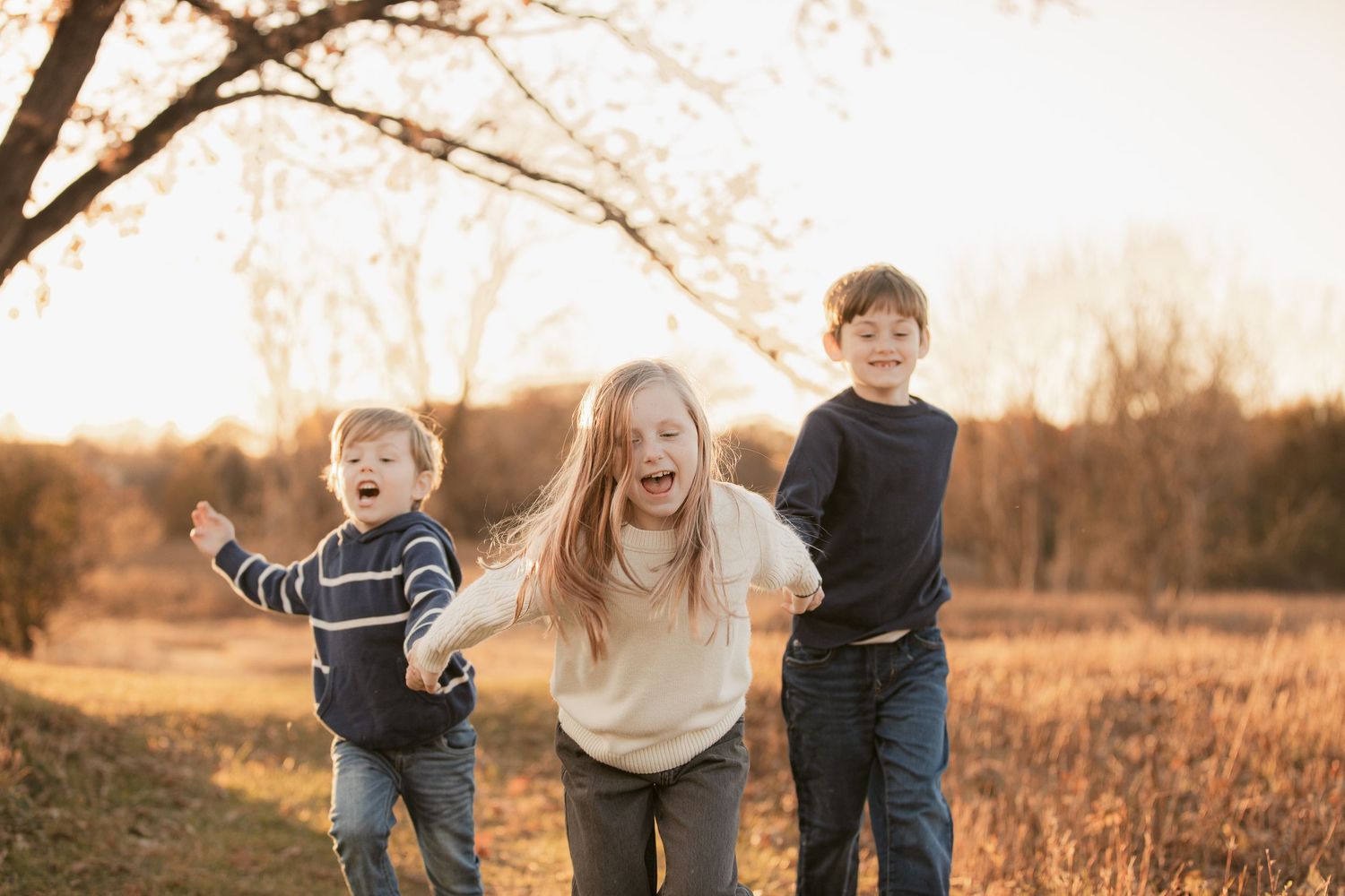 Joyful interaction between people in a sunlit autumn field.