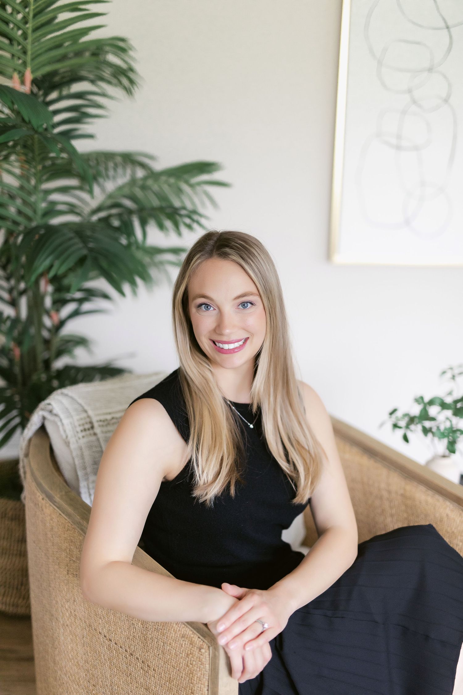 Professional portraits in a bright studio with wicker chair and minimalist decor.