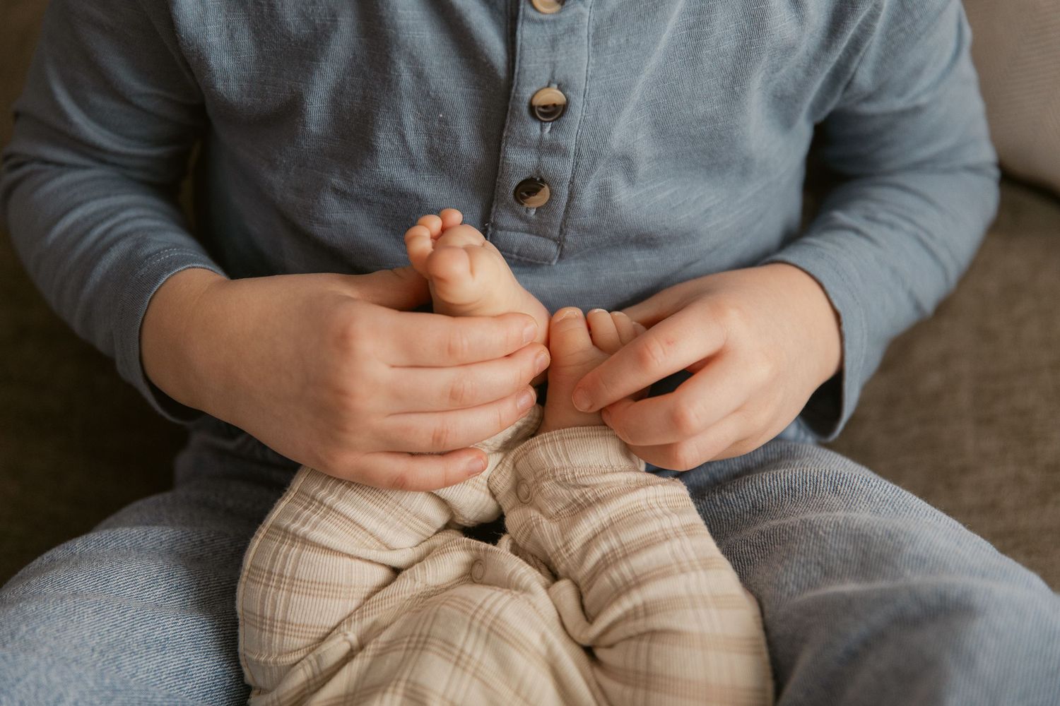 Close-up shots of hands and feet resting on a couch in denim and neutral tones.