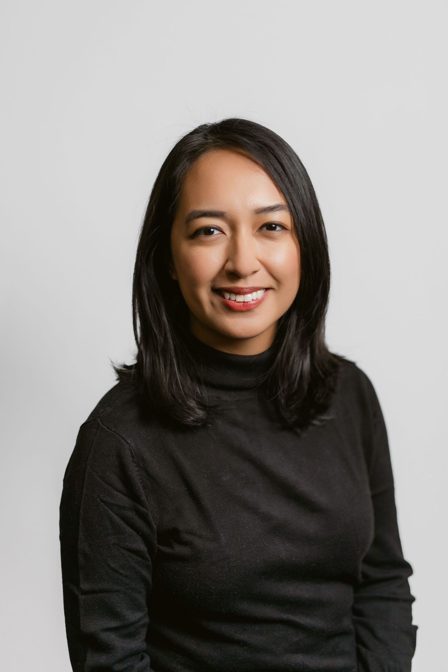 Professional portrait series showing a person in a black sweater against a white backdrop.