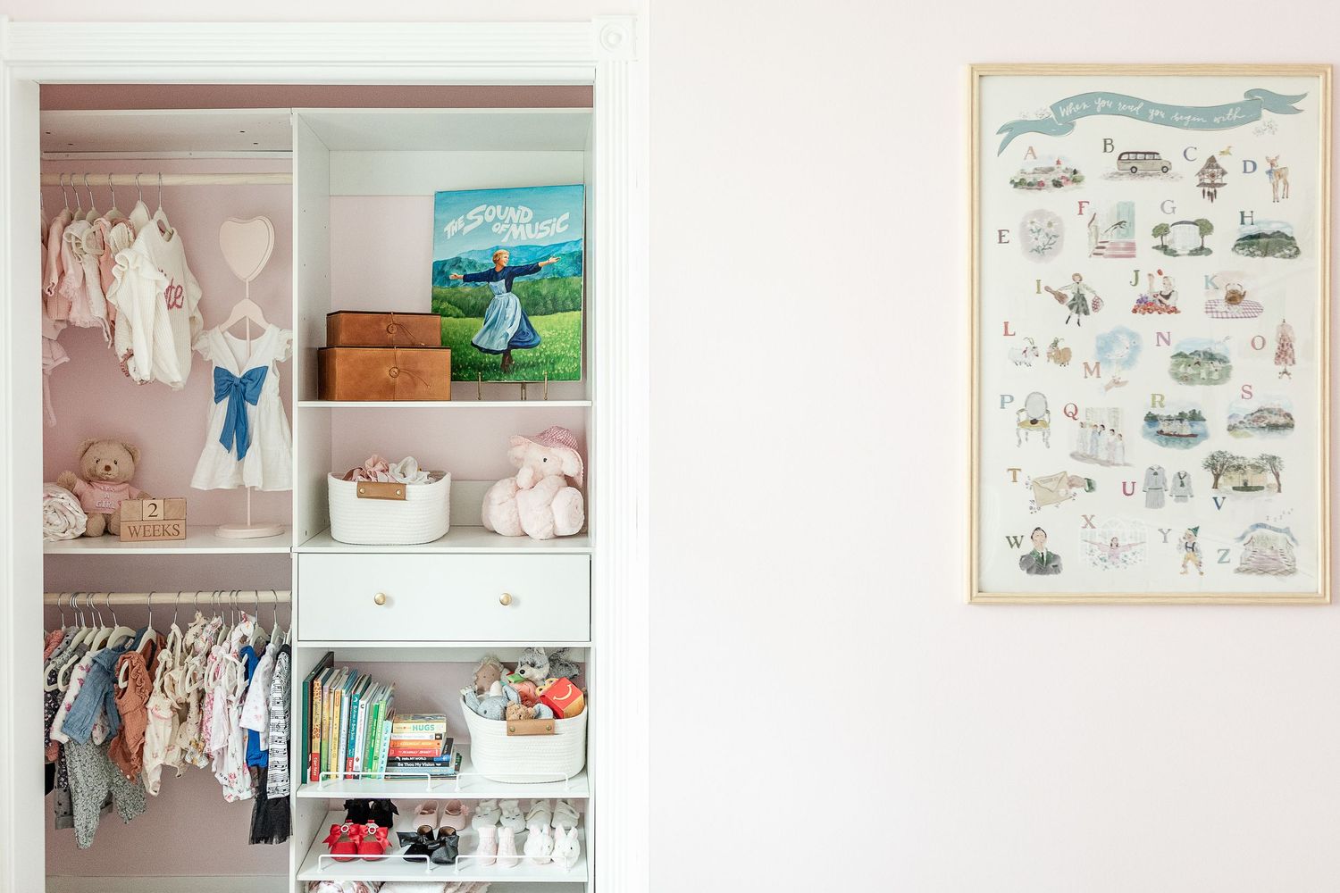 Bright nursery room with white shelving displaying children's books and artwork.