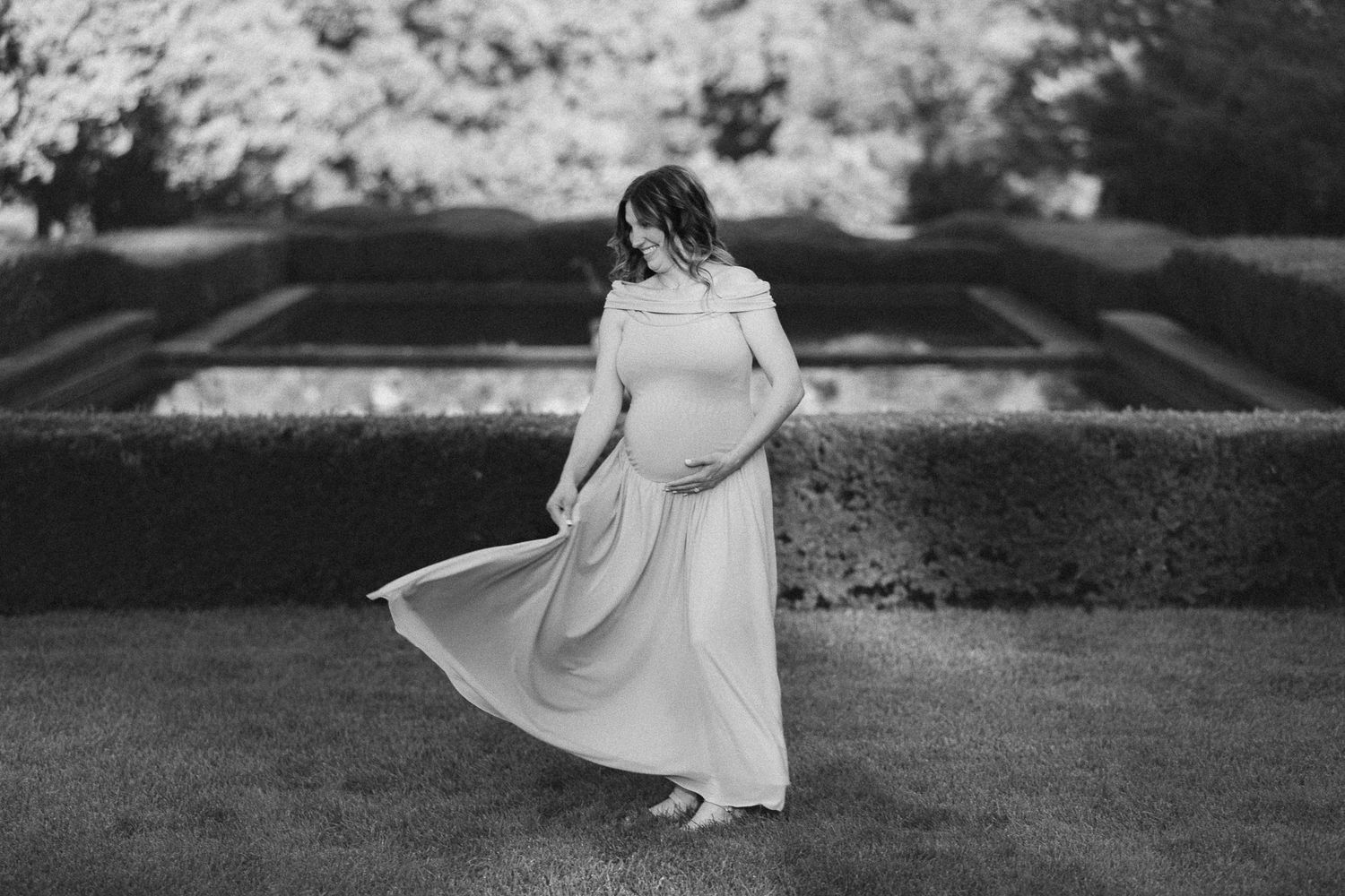 A flowing white dress twirls gracefully in a black and white outdoor scene.