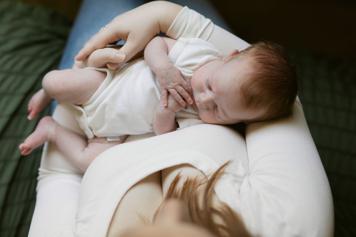 A peaceful scene of a sleeping baby in white clothing against soft textiles.