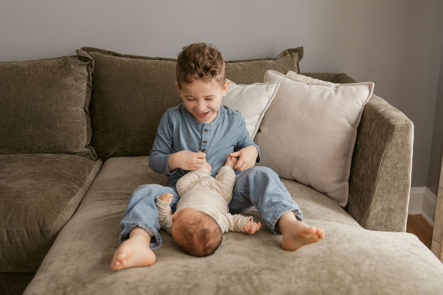 A series of intimate moments on a gray couch showing tender interaction between siblings.