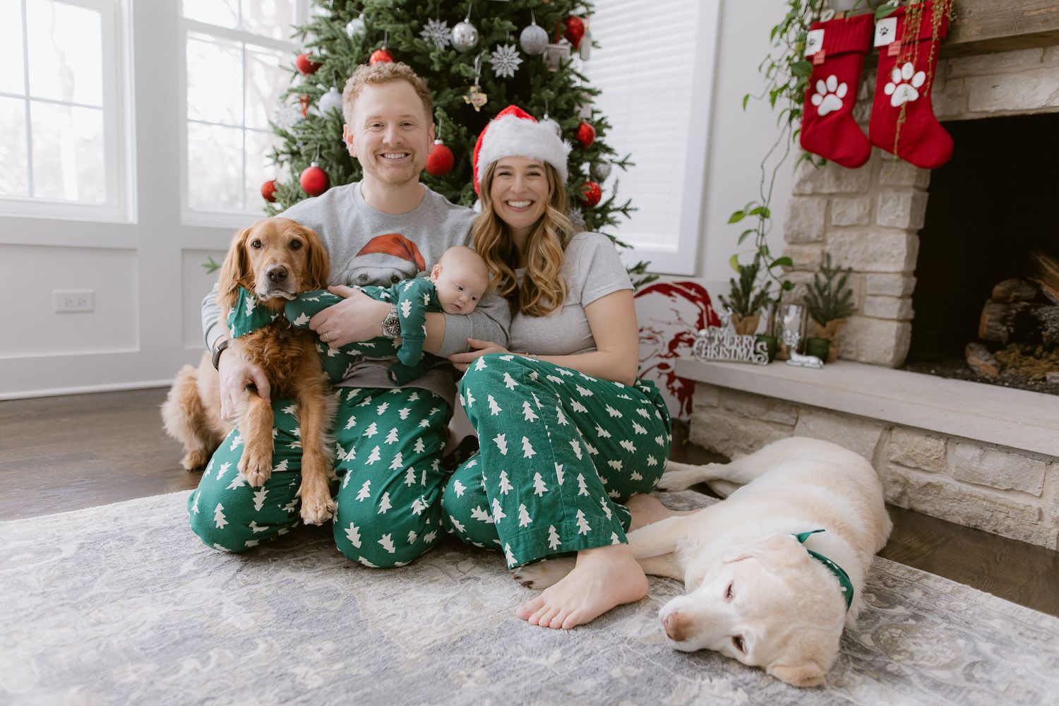 Holiday scene with decorated Christmas tree and family in matching outfits with golden retriever.