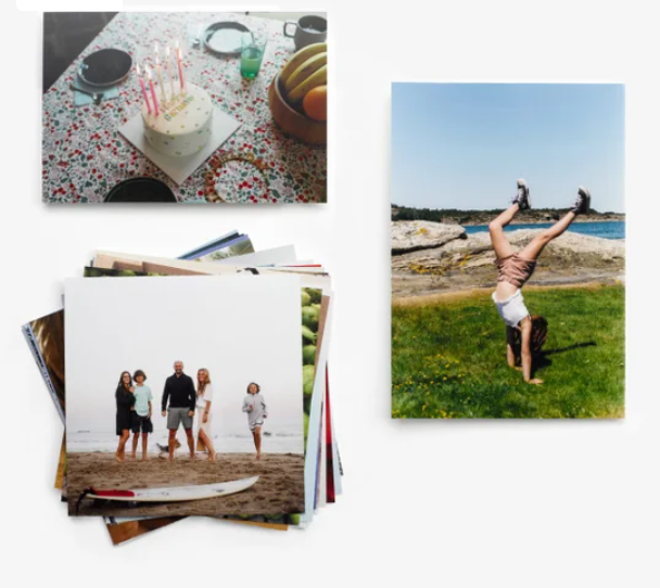 A collage of printed photos including a birthday cake, a family on a beach with a surfboard, and a child doing a handstand.