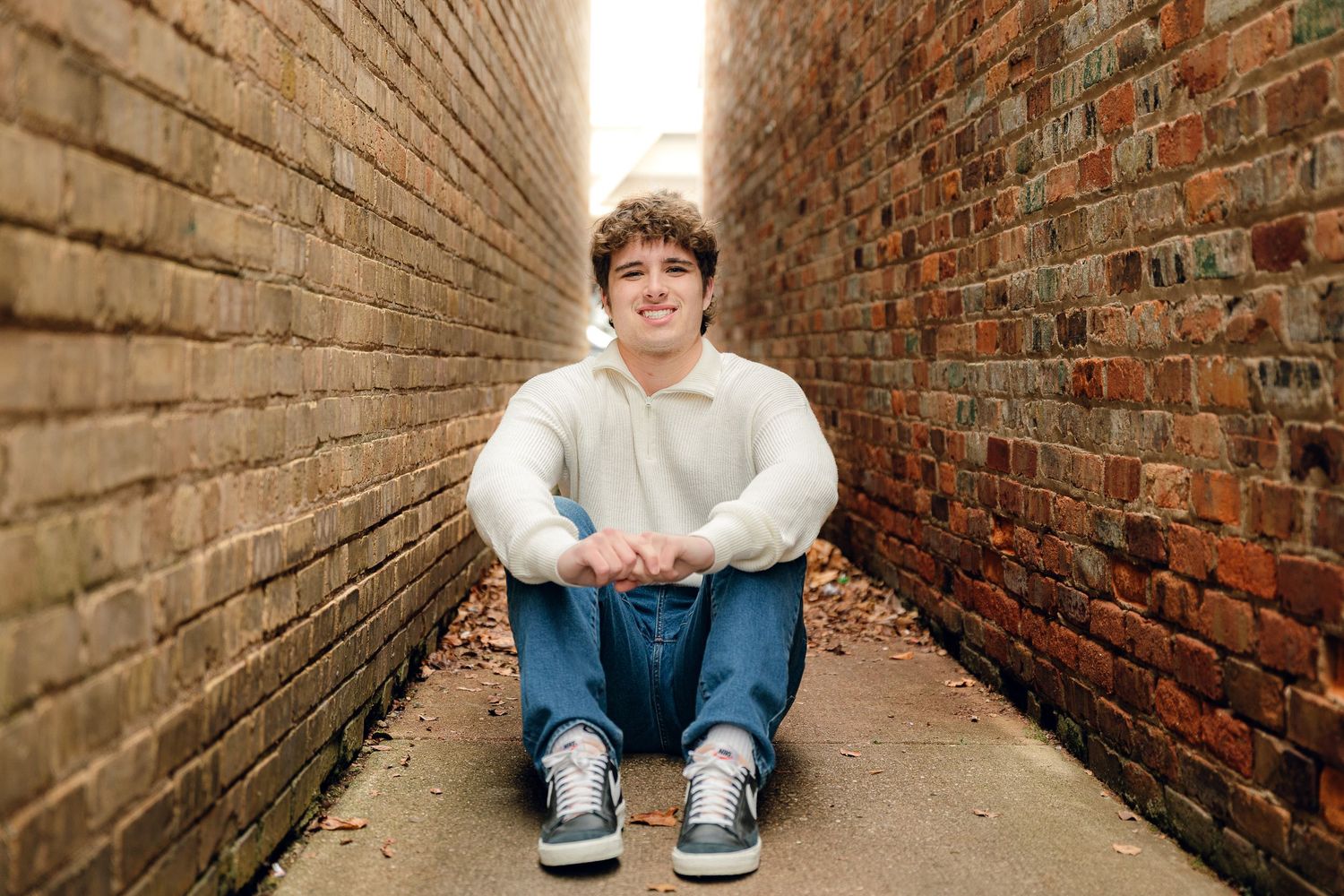 Casual portrait series taken in rustic brick corridor setting.