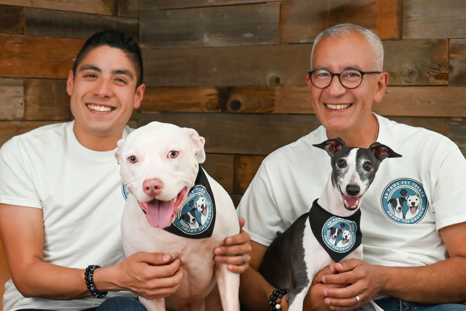 Group photo with white pit bull dogs and matching t-shirts.
