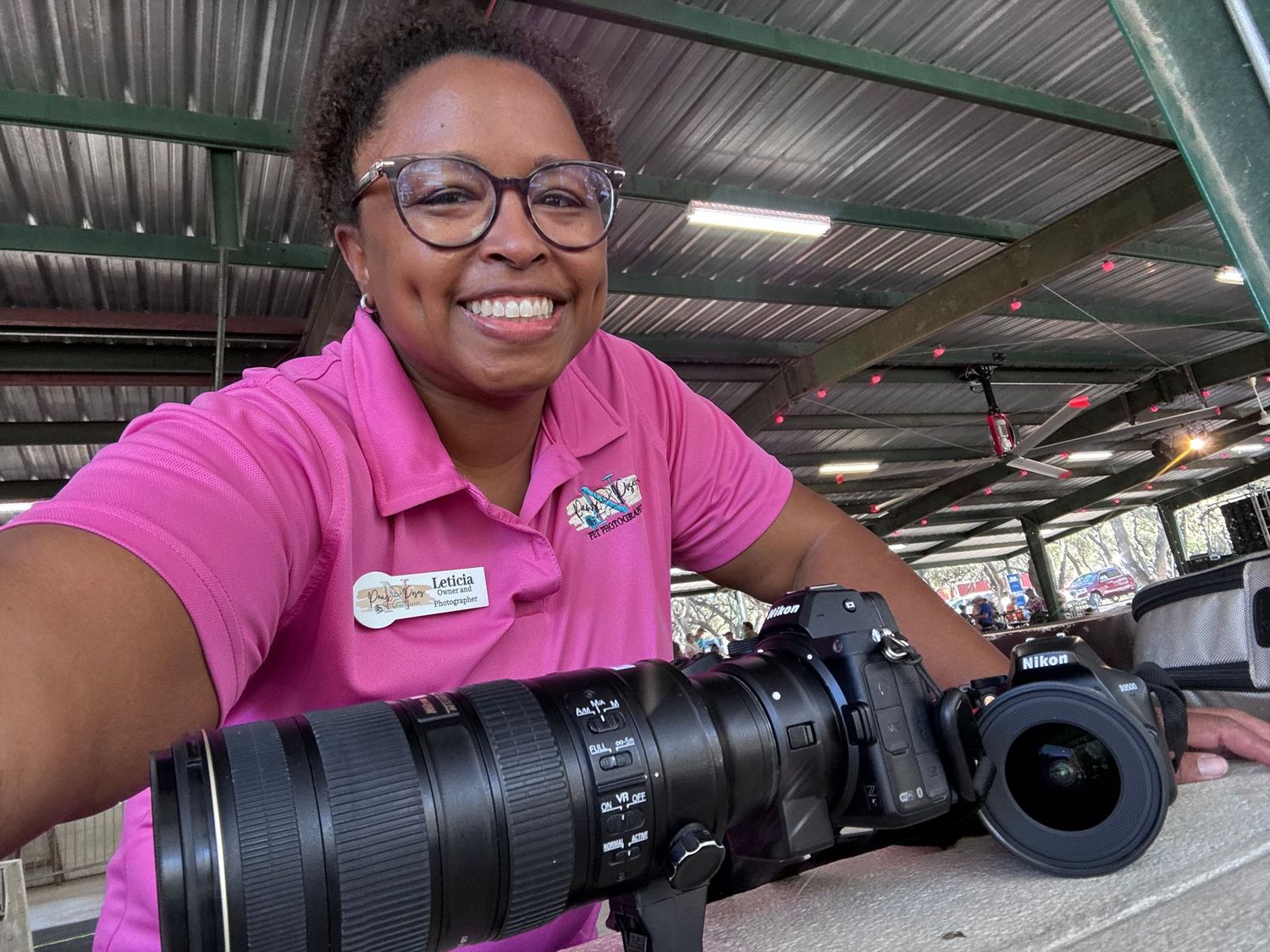 Professional camera equipment displayed against industrial backdrop with pink accents.