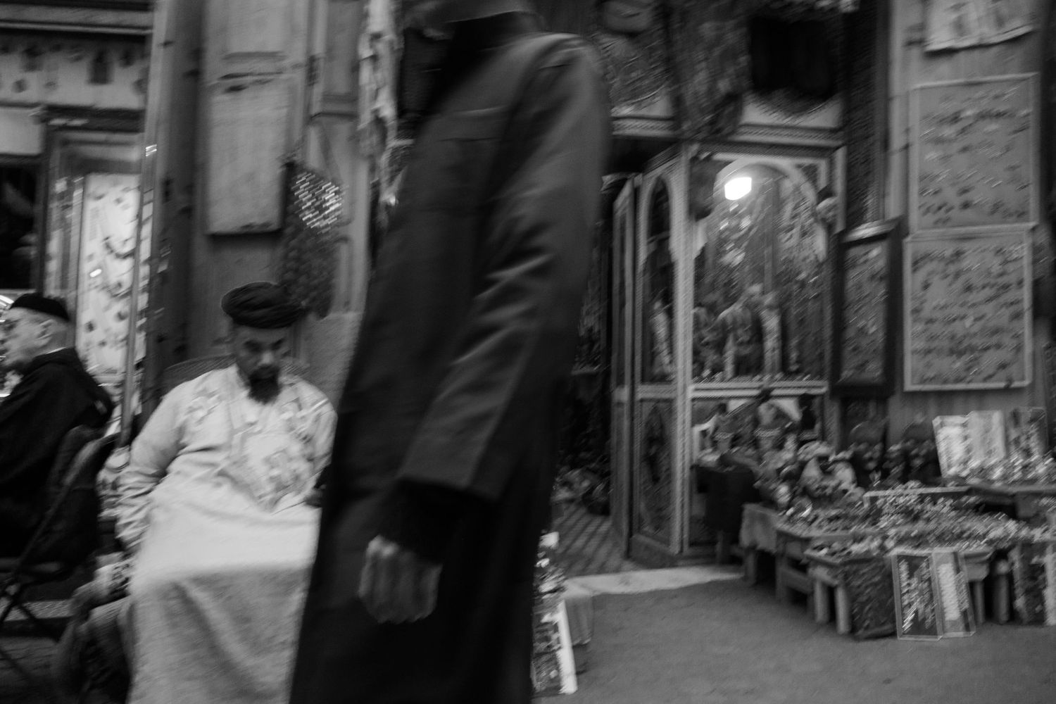 Black and white street photography of a busy market bazaar with blurred pedestrian.