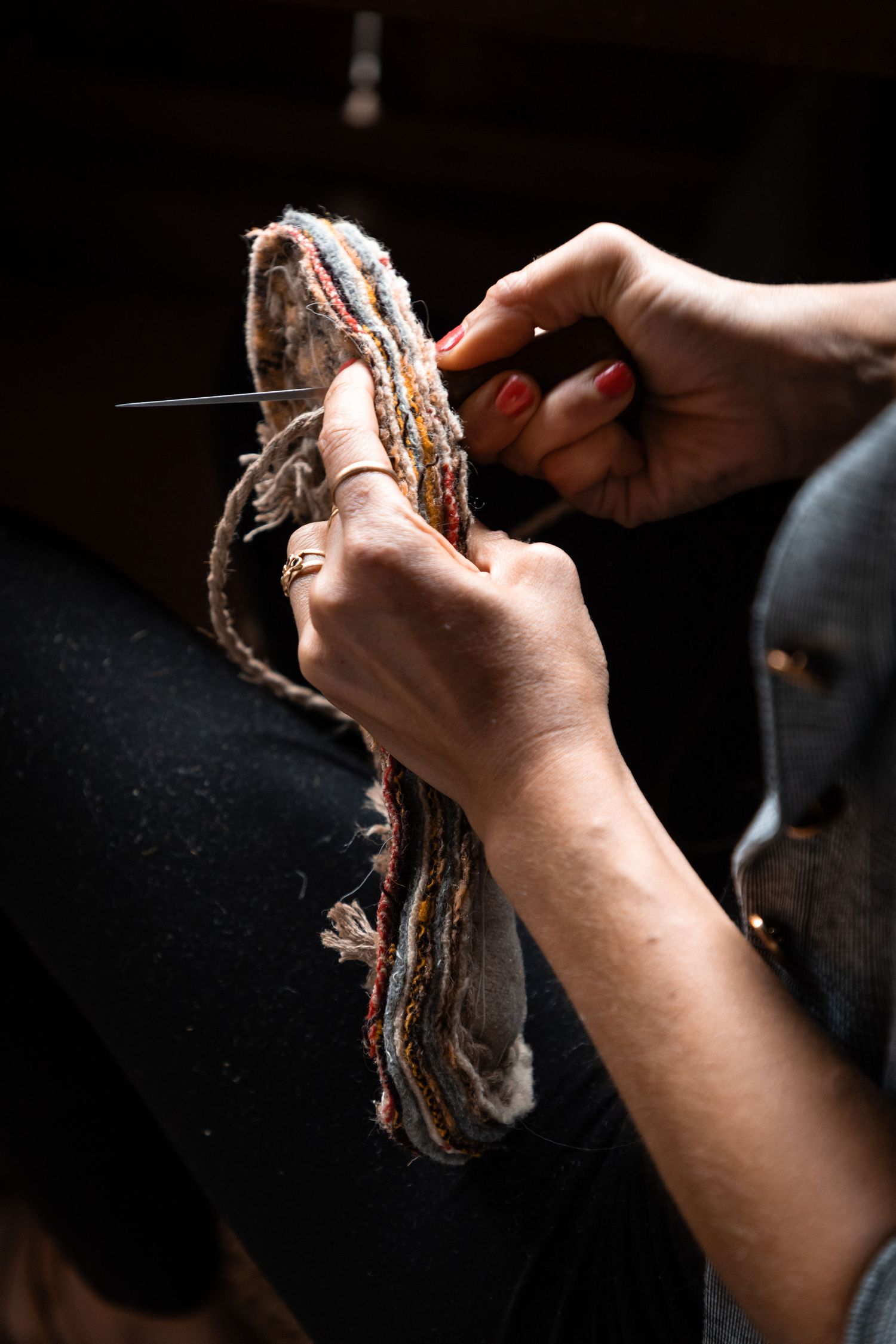 Close-up of hands crafting a traditional woven shoe sole with a needle and thread.