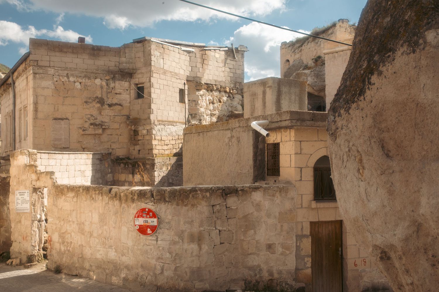 Ancient stone ruins of a historic building with a red stop sign on a weathered wall.