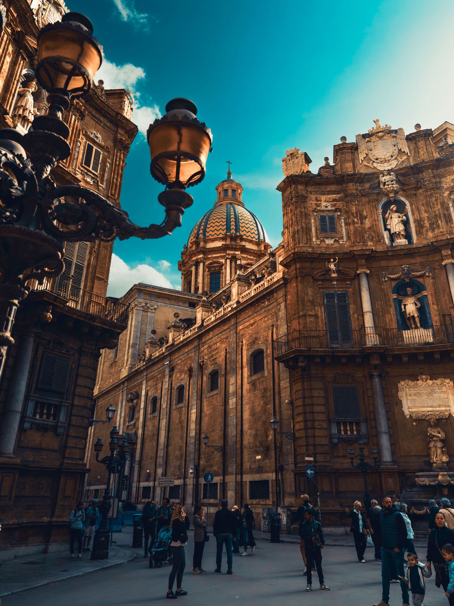 Historic baroque church exterior with ornate architecture and golden stone facades under vibrant blue sky in Sicily, Italy.