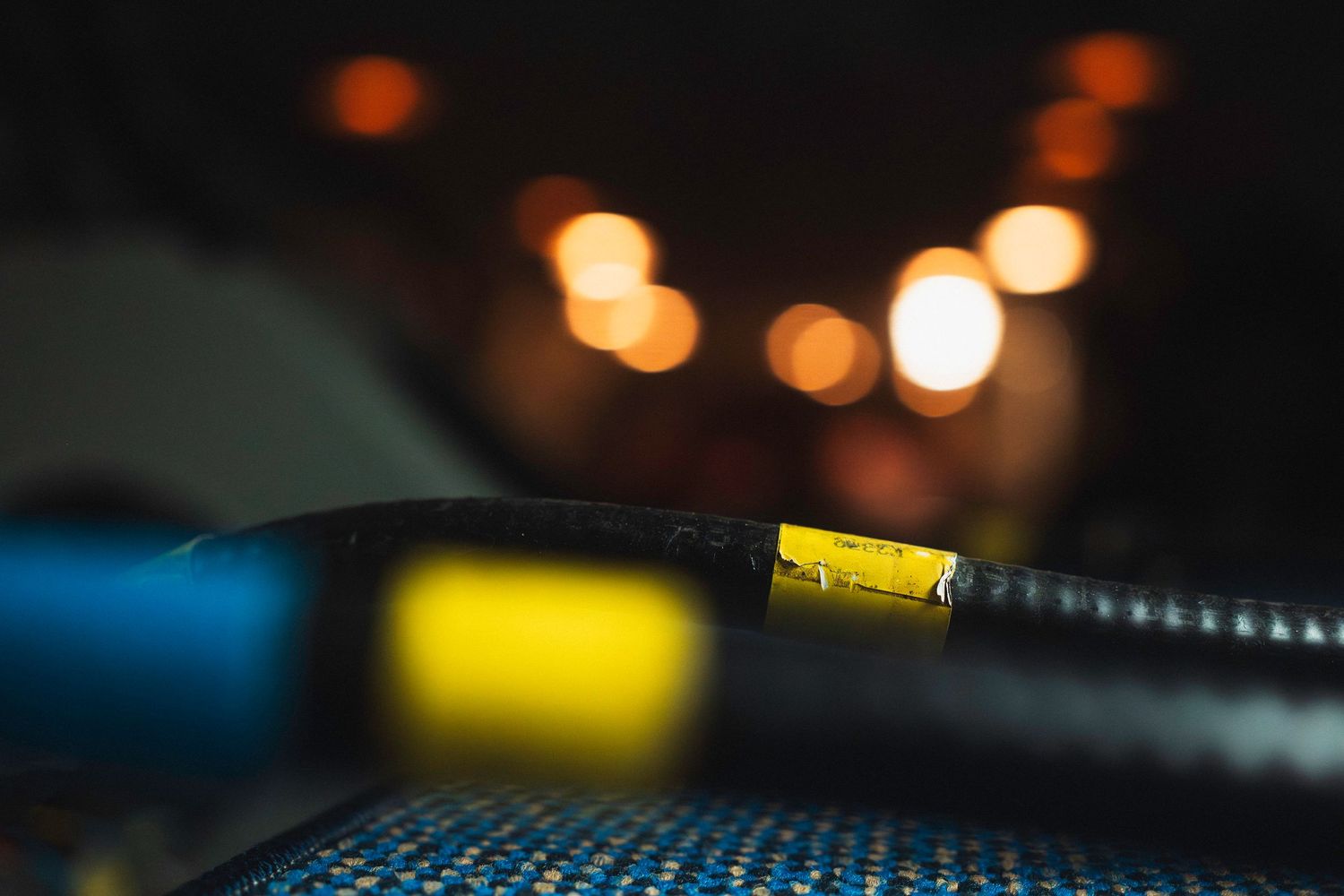 Blurred bokeh lights create an atmospheric background effect in dark setting with yellow and orange glowing orbs.