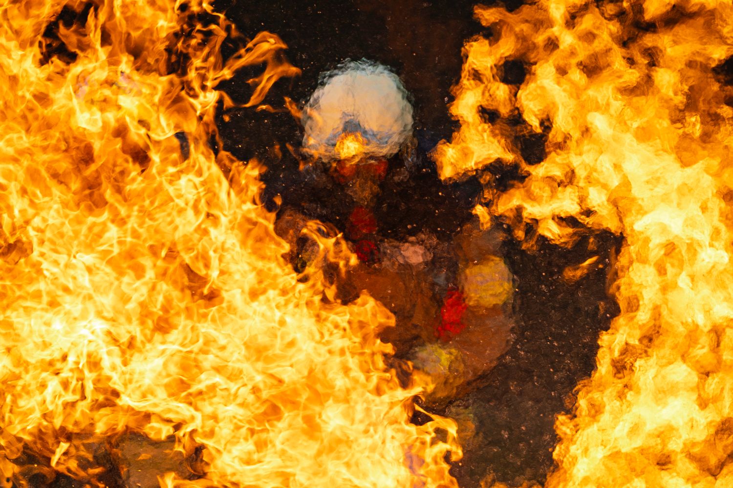 Bright orange flames and fire engulf the frame against a dark background creating an intense display of combustion.