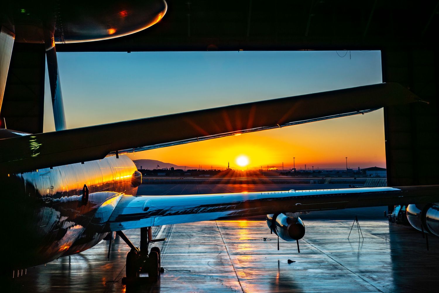 Vibrant orange sunrise in front of a NATO AWACS E-3A aircraft. Creating a stunning landscape view.