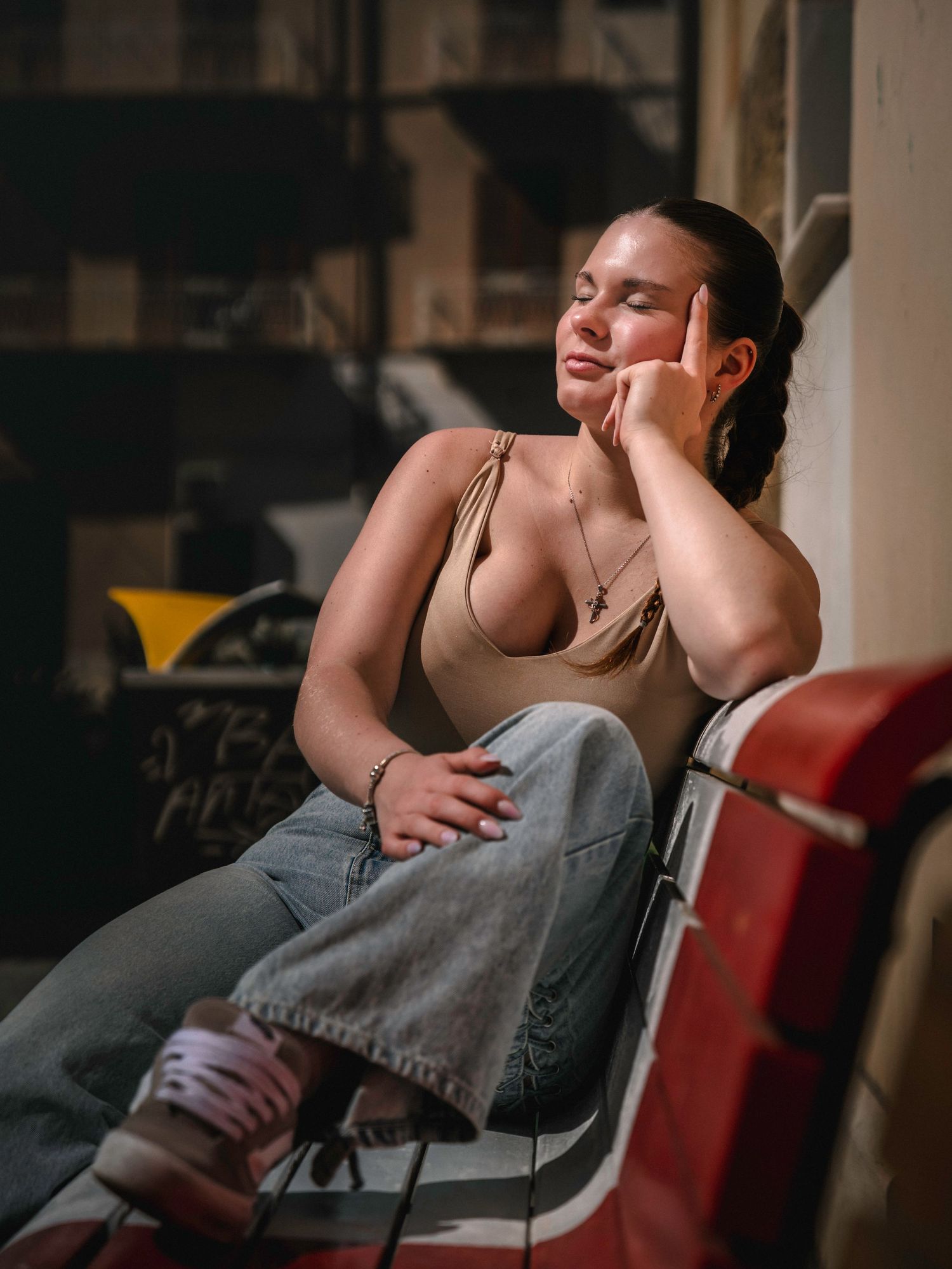 Person resting in a chair with dramatic lighting creating a moody, contemplative atmosphere.