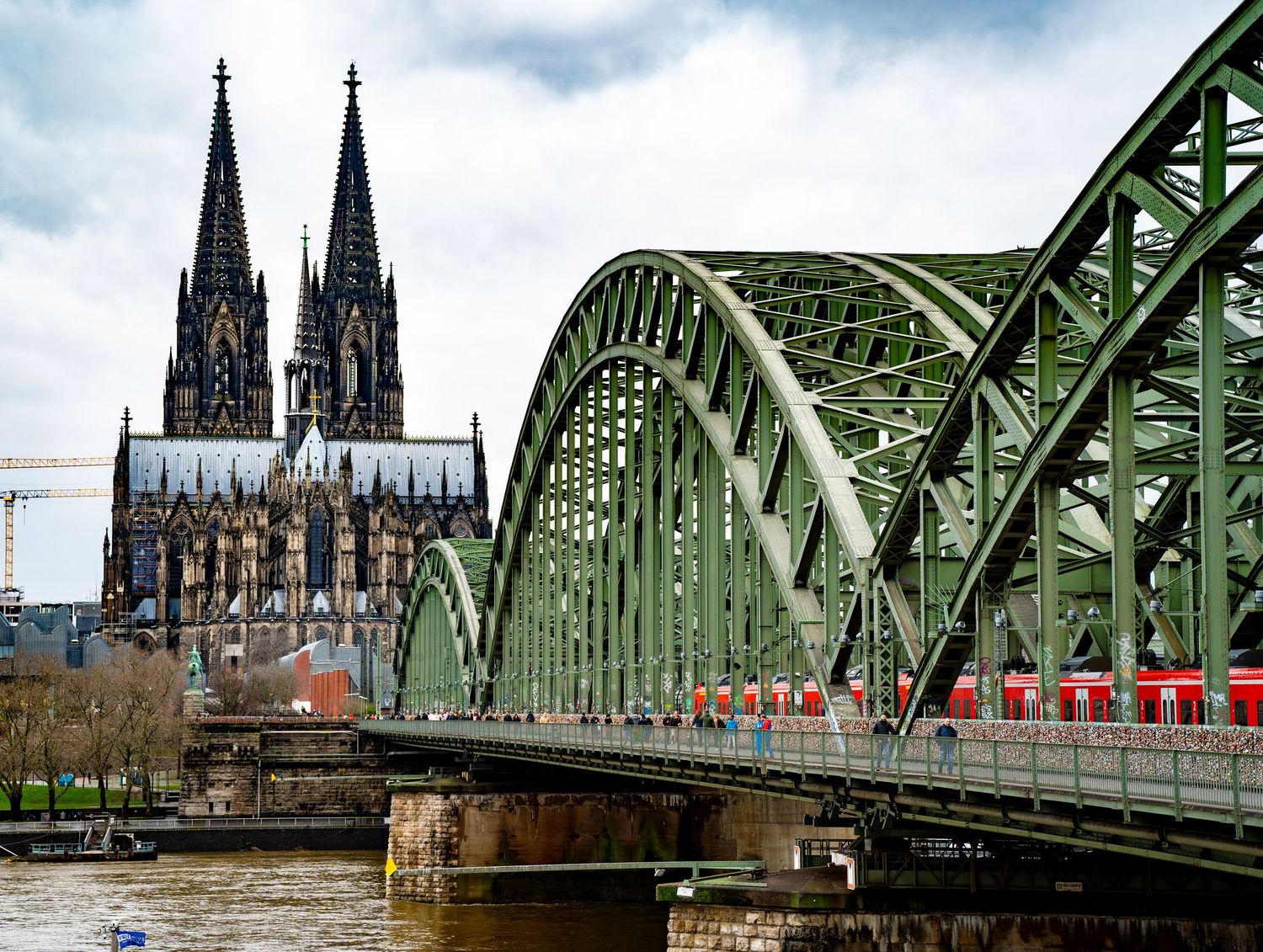 Panoramic view of Cologne Cathedral and the Hohenzollern Bridge spanning the Rhine River.
