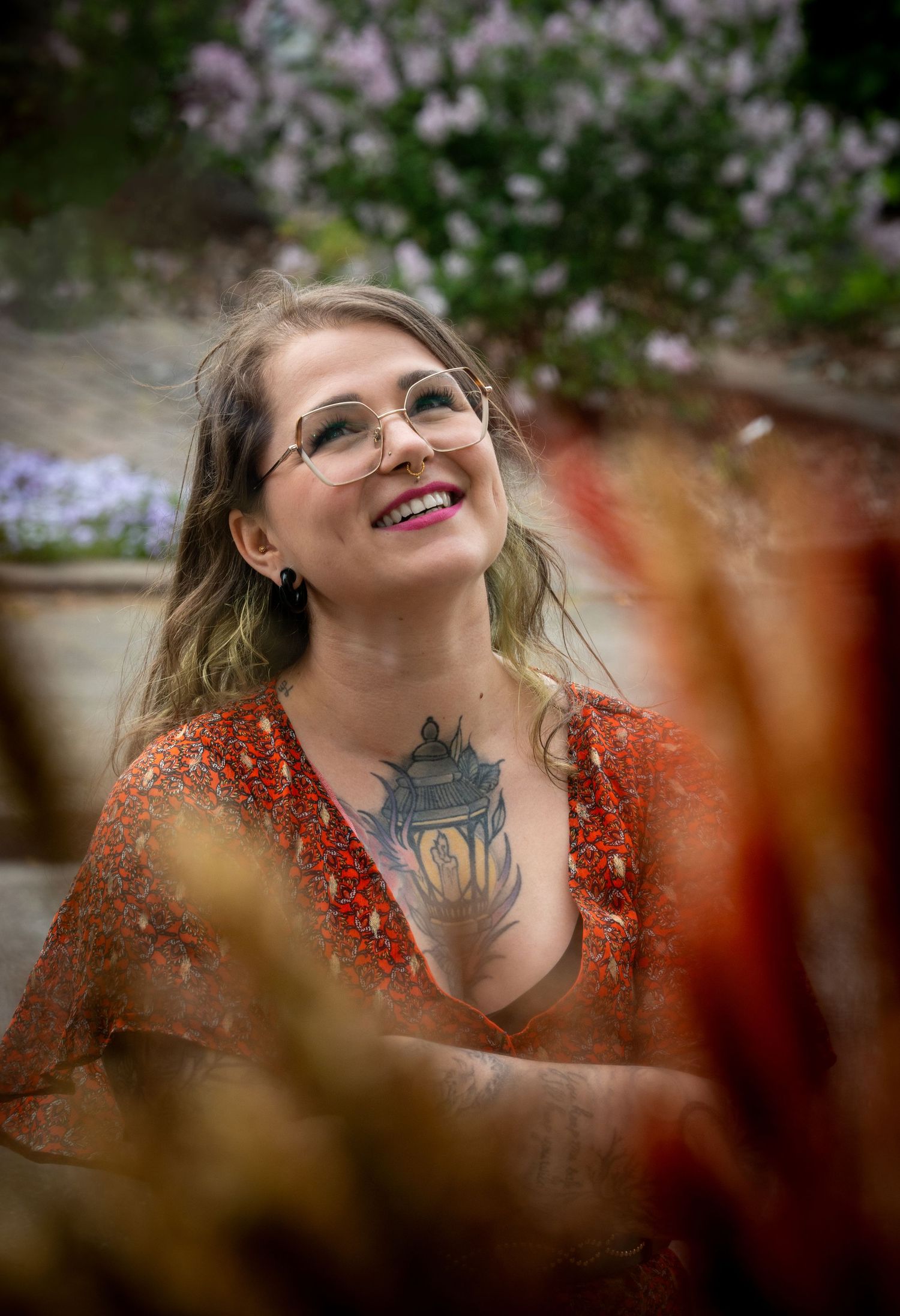 Portrait of a woman photographed for a tattoo shop, surrounded by foliage.