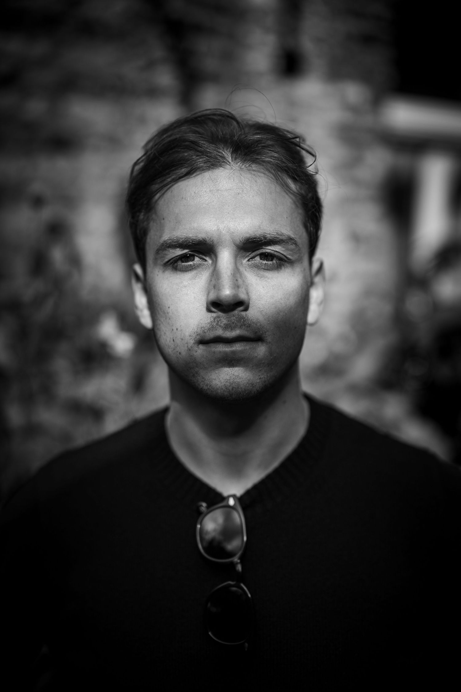 A dramatic black and white portrait of a man showing with moody lighting.