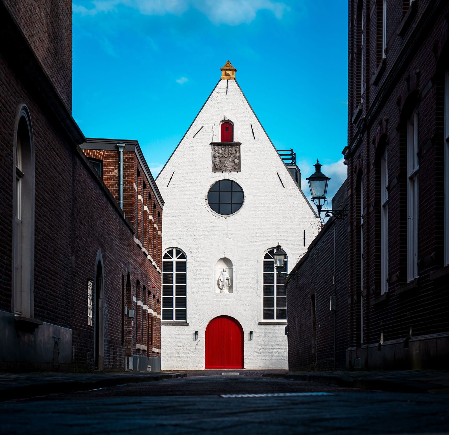 Architectural photograph of a historic building in Maastricht framed by a narrow street.