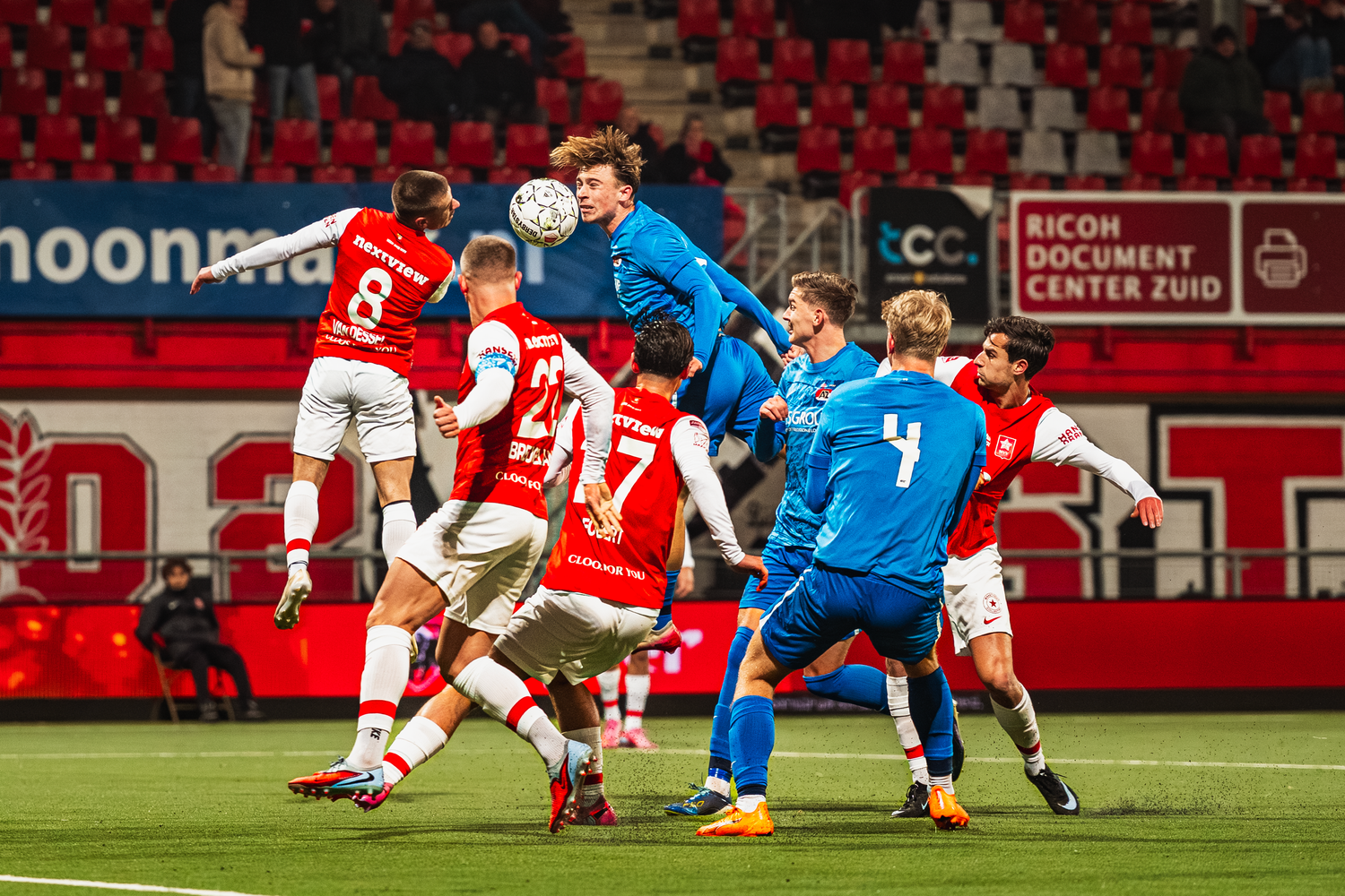 Action photograph of a professional soccer match with players contesting a header.