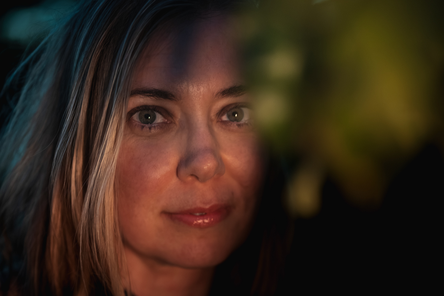 A close-up portrait photo of a woman smirking at the camera.