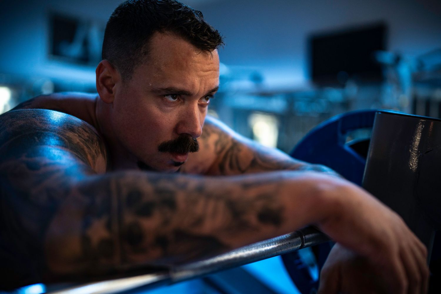A dramatic portrait showing a bodybuilder on a bench press bar after completing an exercise.