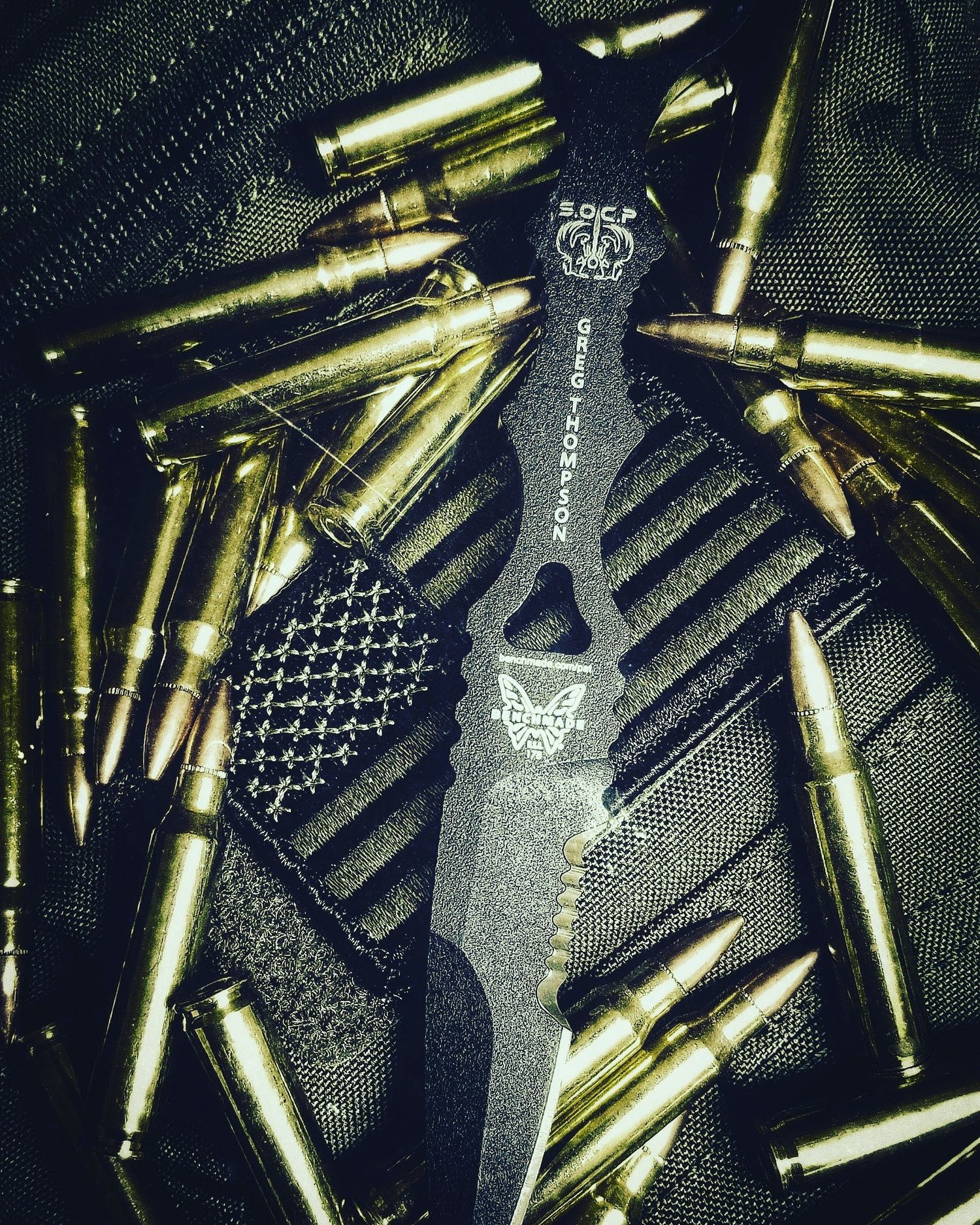 Close-up photograph of a fixed-blade knife placed among rifle cartridges.