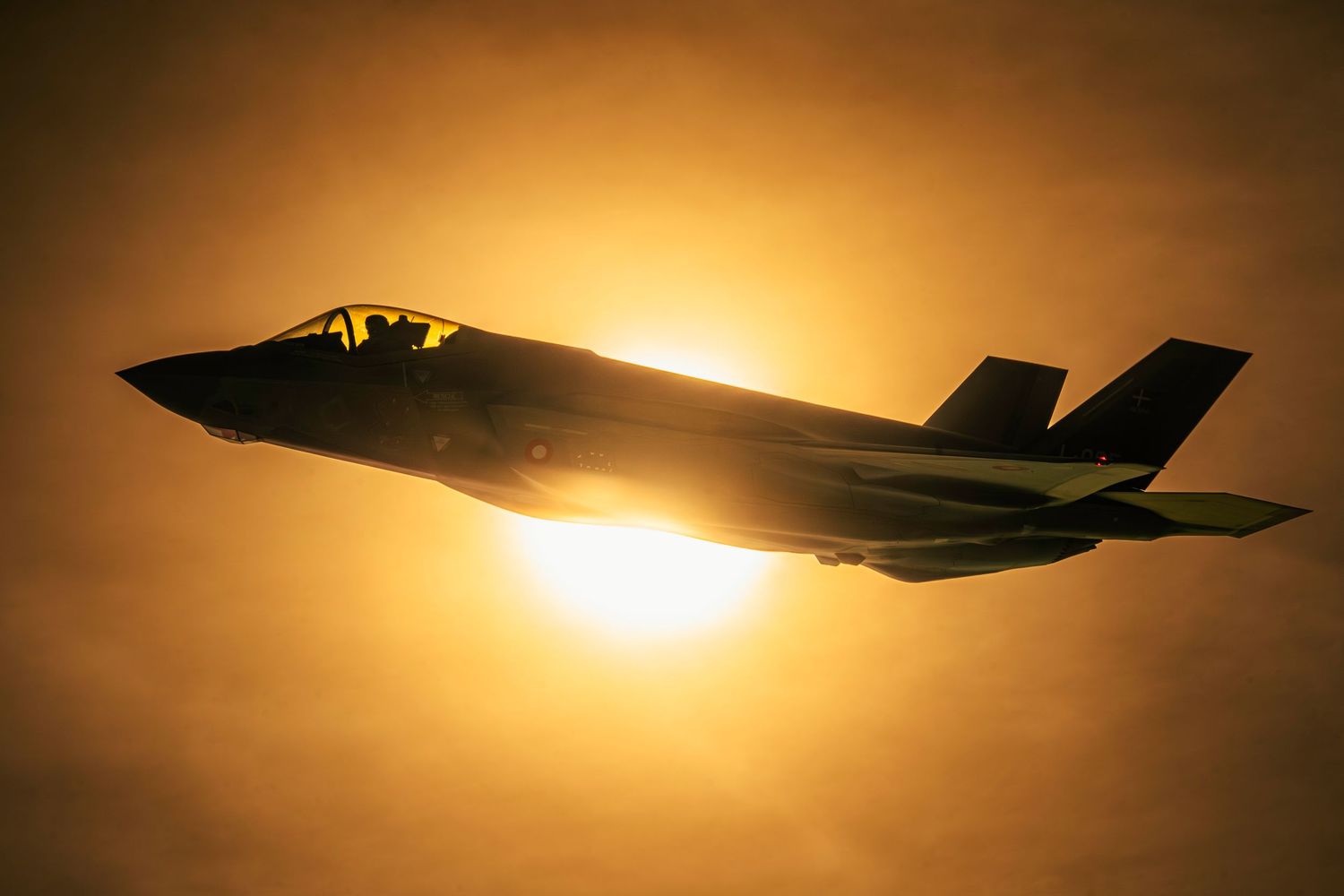 Silhouette of an F-35 fighter jet during an aerial refueling mission.