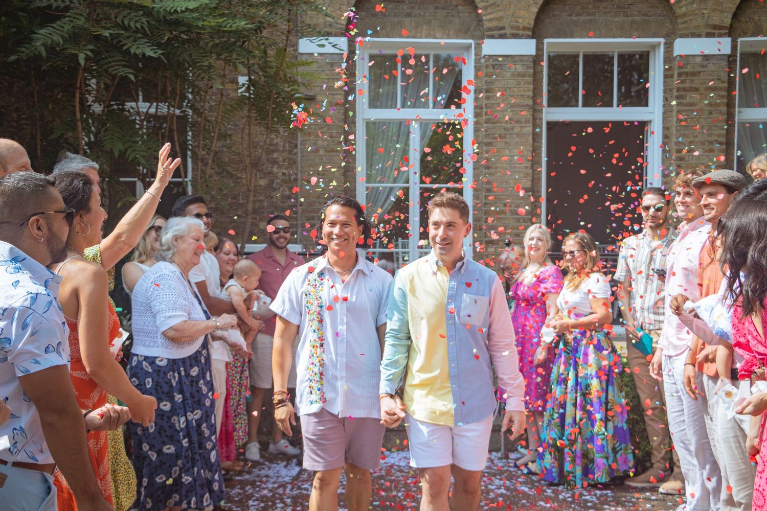 candid photo Candid LGBTQ+ wedding photo of two grooms celebrating with confetti after their ceremony in the Kitchener–Waterloo Region