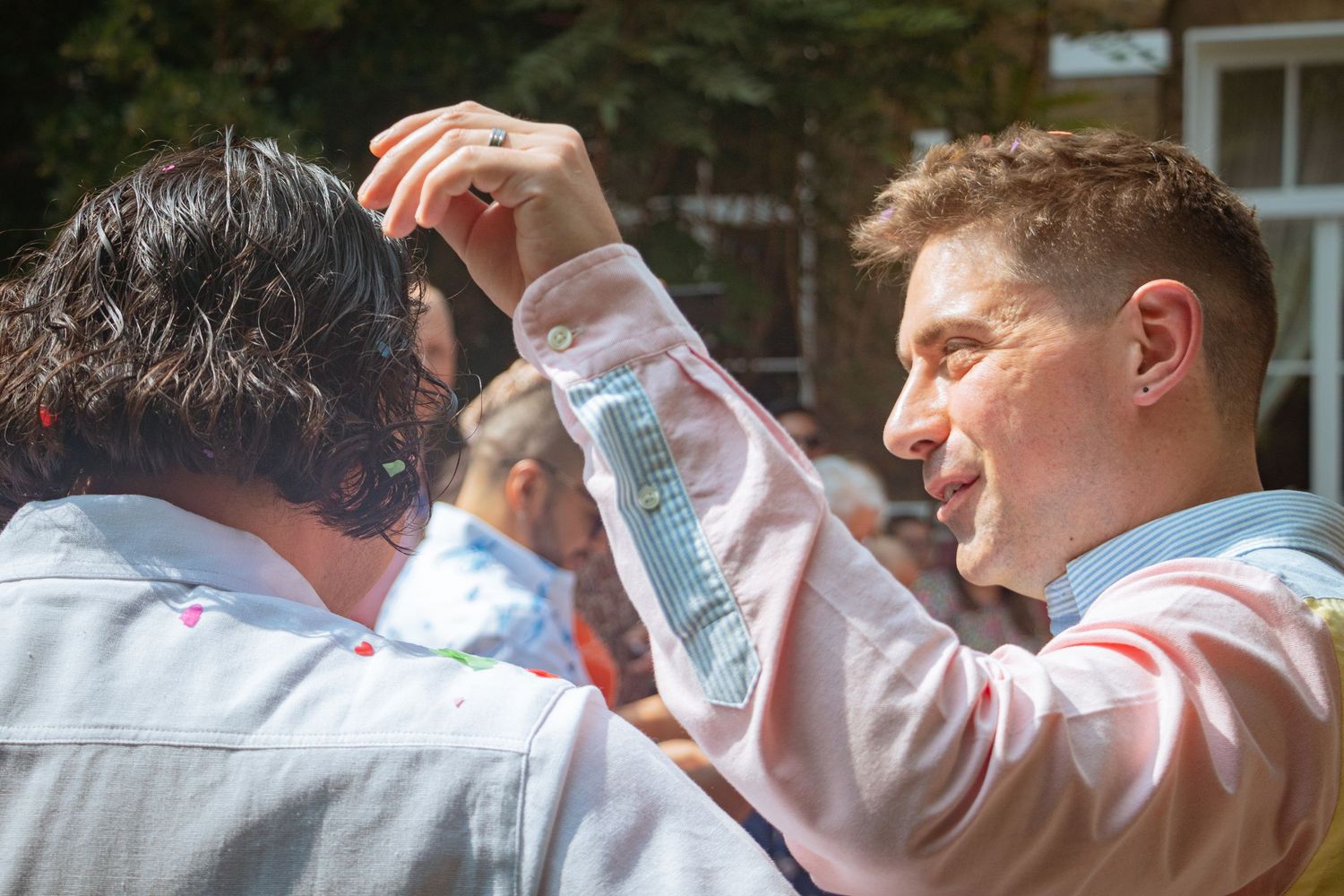 Candid LGBTQ+ wedding photo of two grooms celebrating with confetti after their ceremony in the Kitchener–Waterloo Region