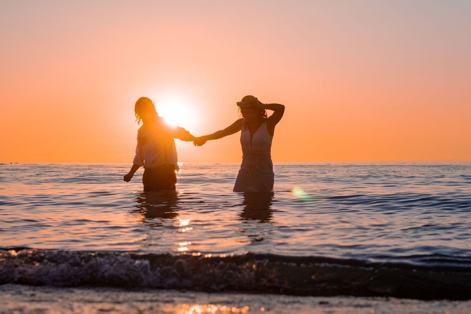 bride and groom holding hands in front of the sunset at kitchener–Waterloo Cambridge Region