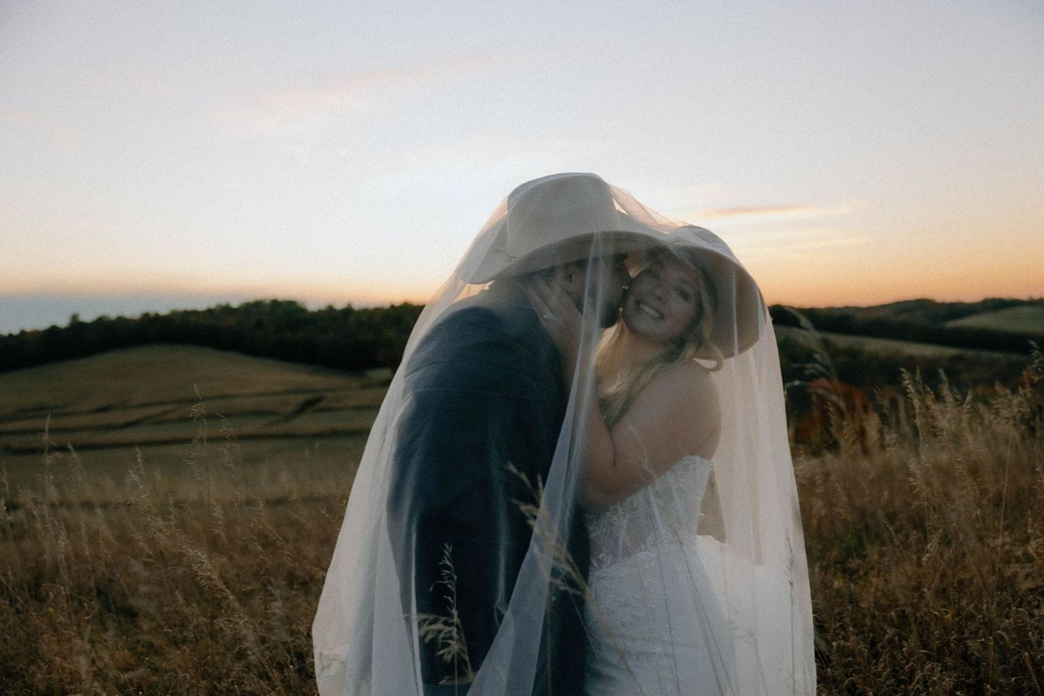 A romantic sunset photoshoot in a golden field with soft lighting and dramatic shadows.