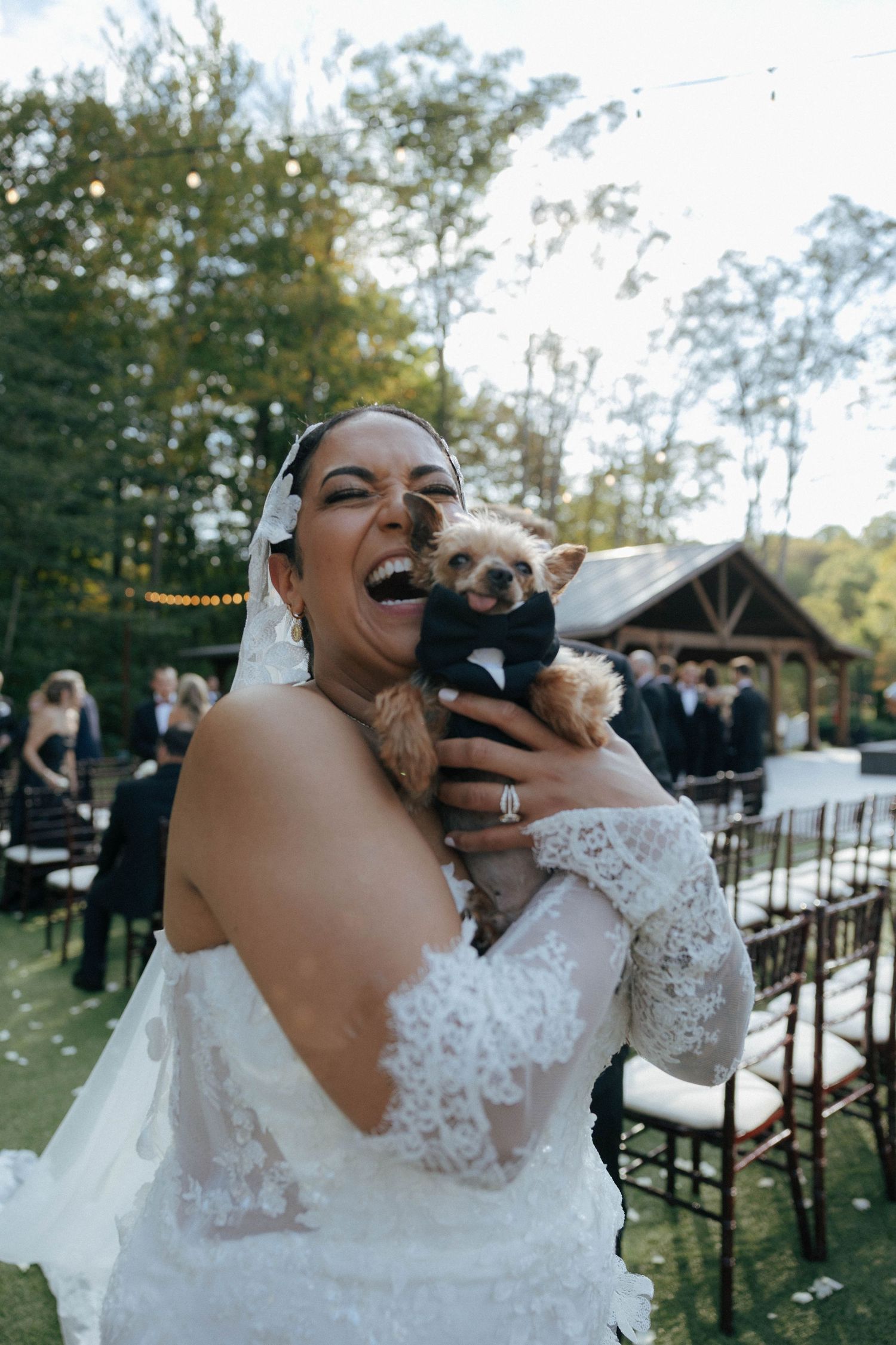Wedding moment captured outdoors with white lace dress details and autumn scenery.