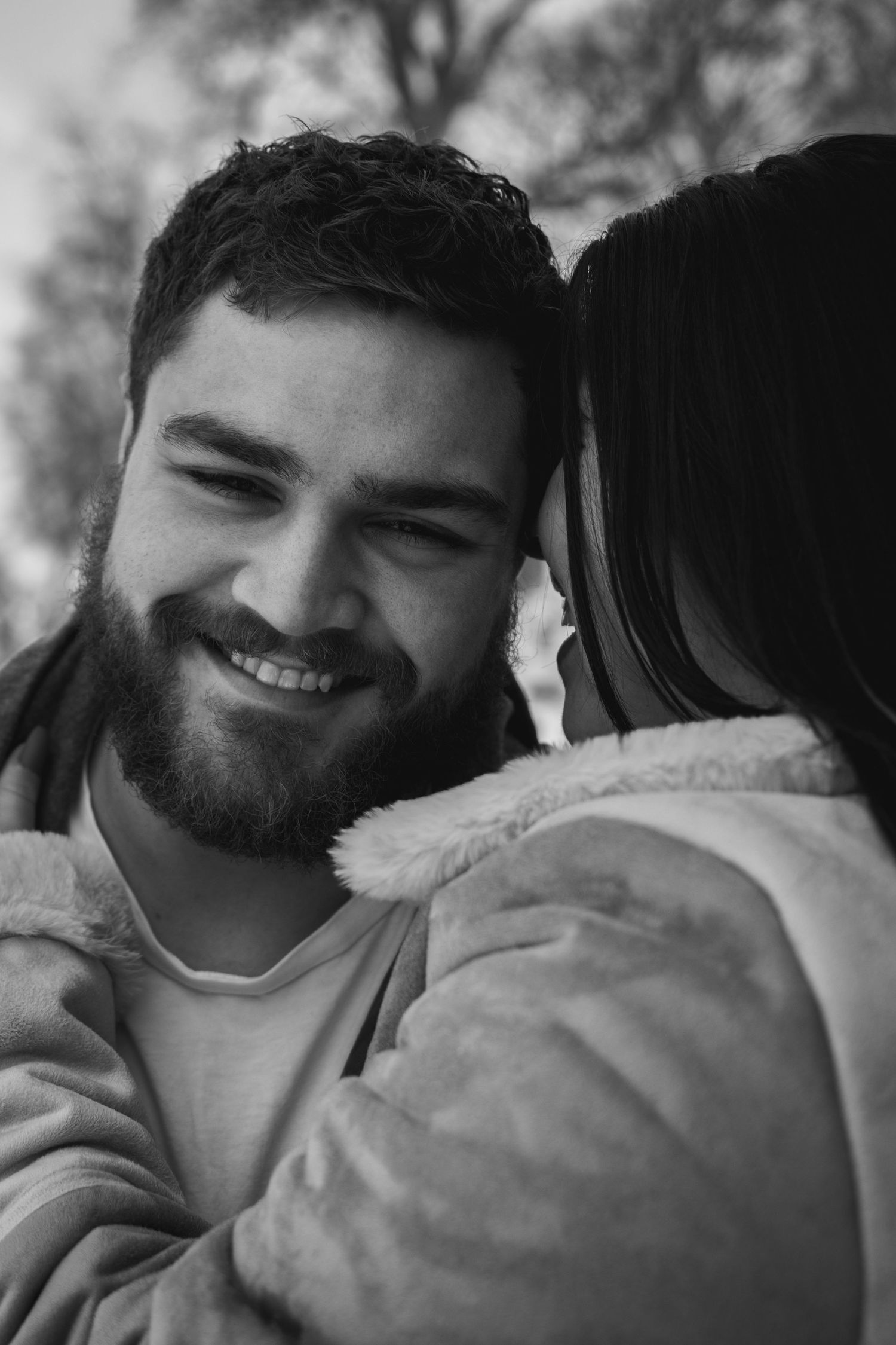 B&W close-up portrait of couple whispering in Mt. Hope Cemetery, Rochester NY. Intimate, candid session.