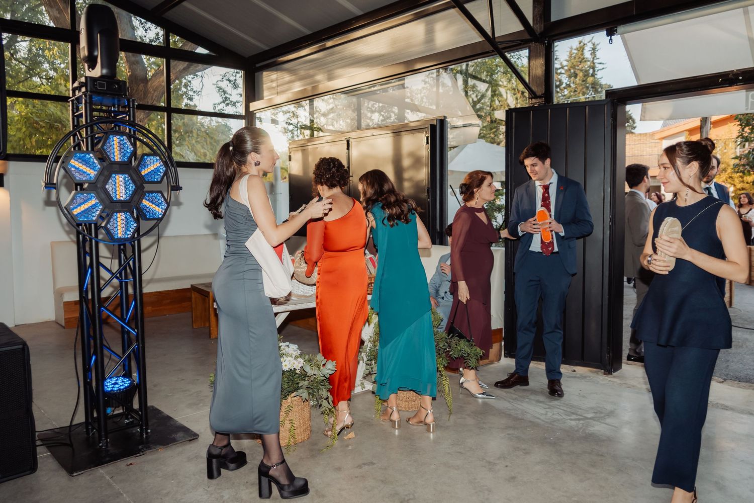 Wedding guests socializing near a prize wheel at a modern indoor venue during a reception.