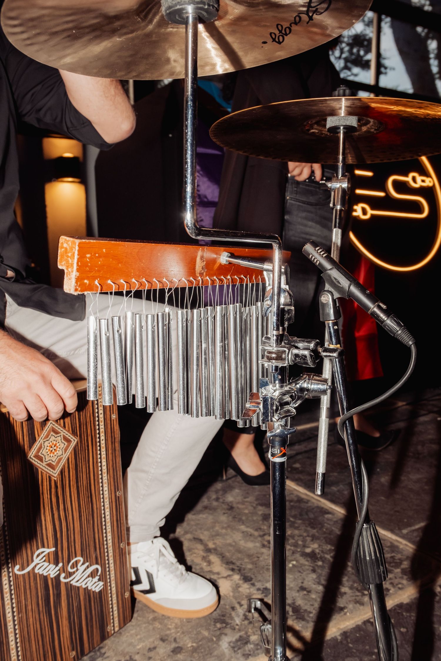 Close-up of percussion instruments including a cajon and wind chimes being played at a live wedding band.