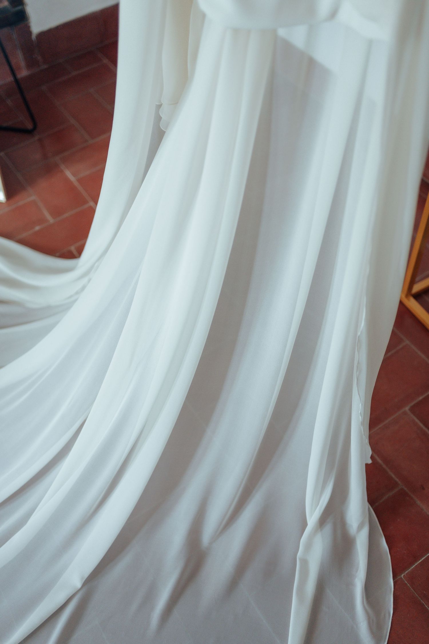 Close-up of flowing white wedding dress fabric with soft elegant draping.