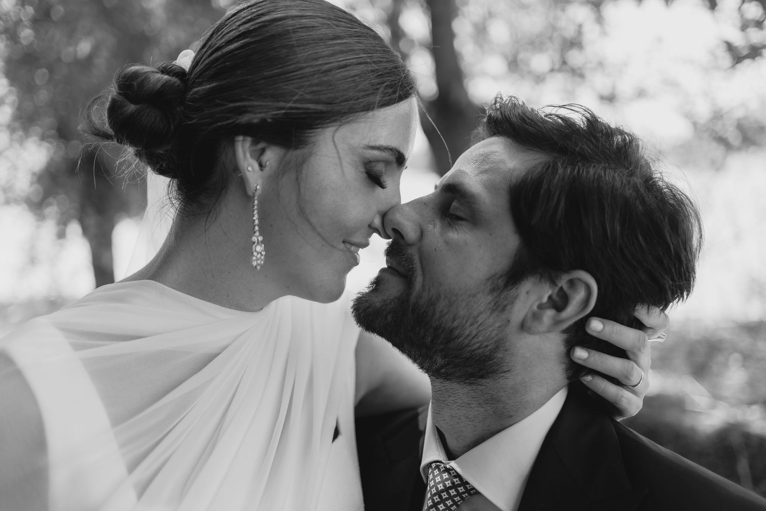 Black and white photo of bride and groom sharing an intimate moment, almost kissing at their wedding.