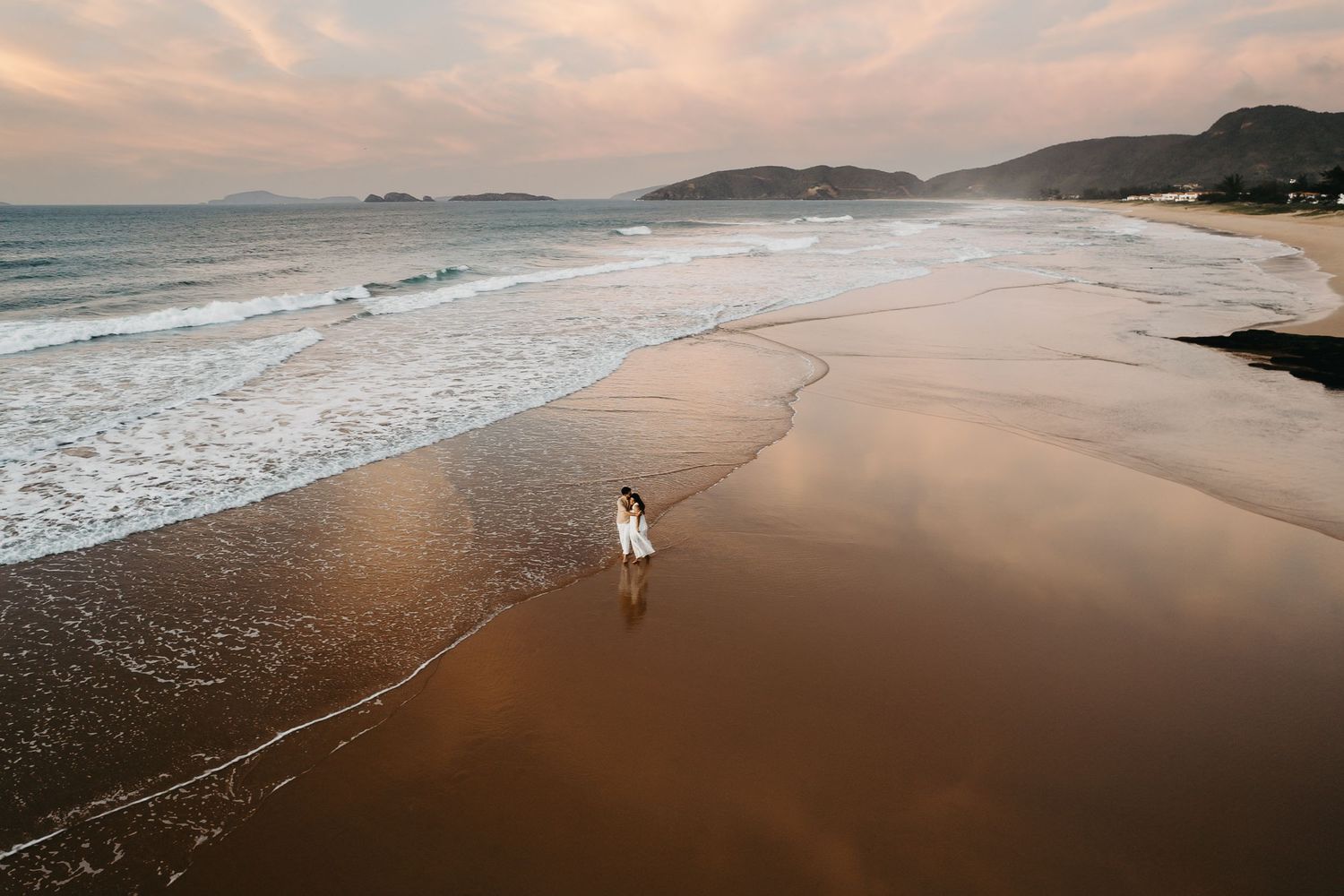 Vista aérea da Praia de Tucuns em Búzios durante ensaio pre-wedding no pôr do sol.